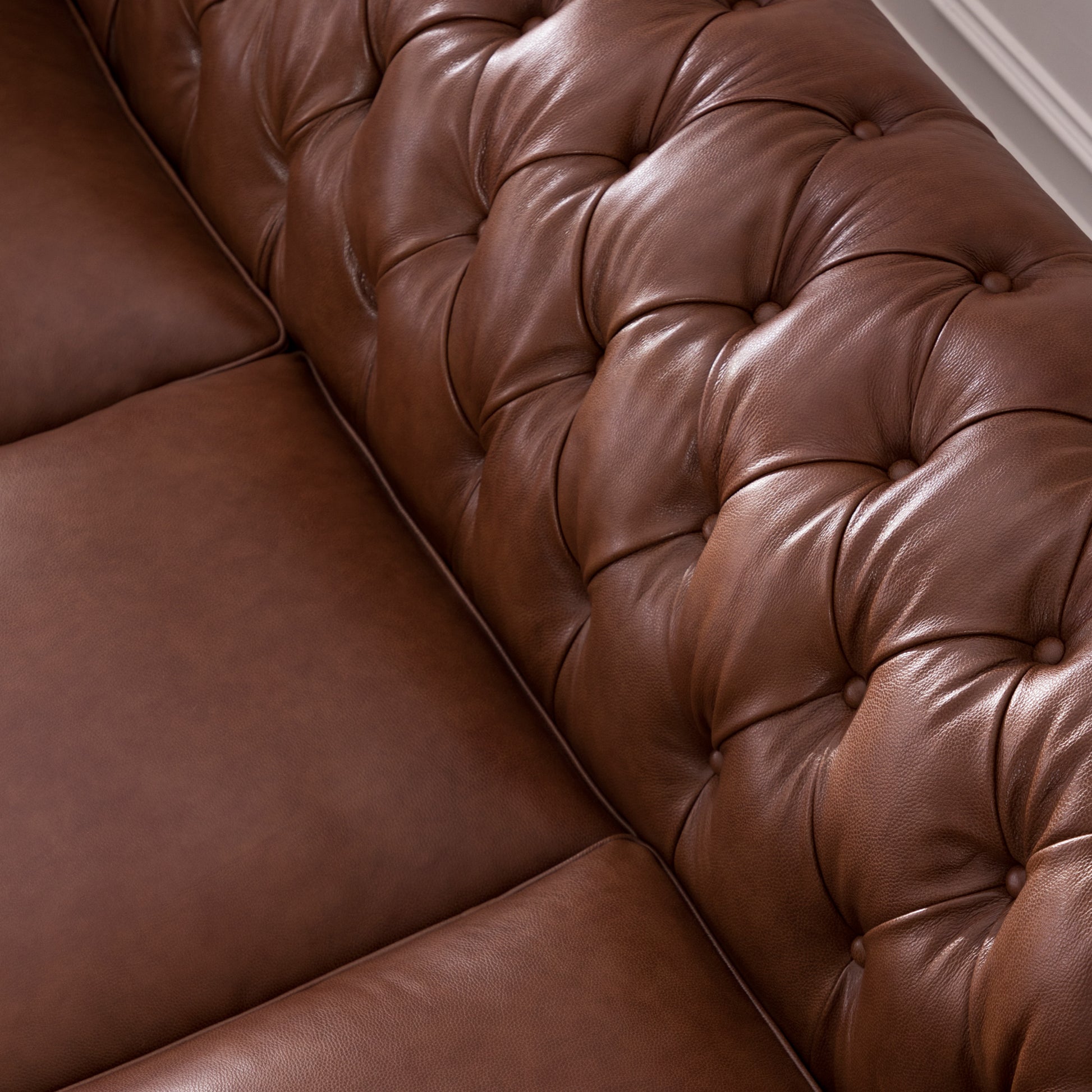 Rich brown leather Chesterfield sofa detail with button tufting