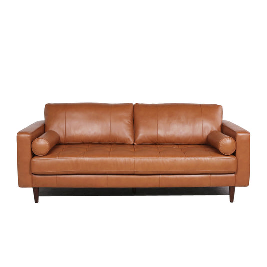 Tan leather sofa with tufted seat cushions and bolster pillows