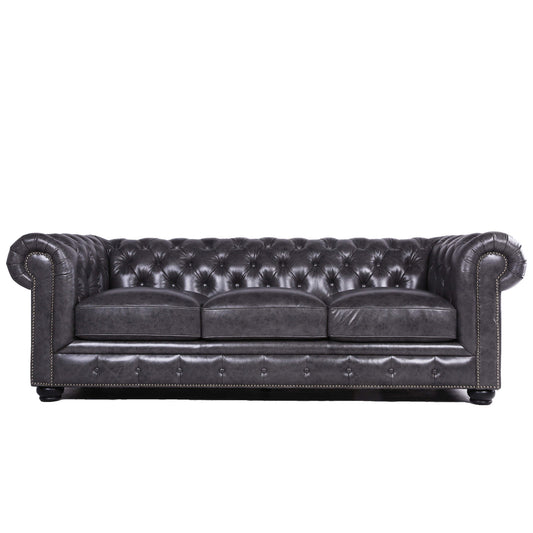 Dark gray tufted leather sofa with silver nailhead trim and rolled arms