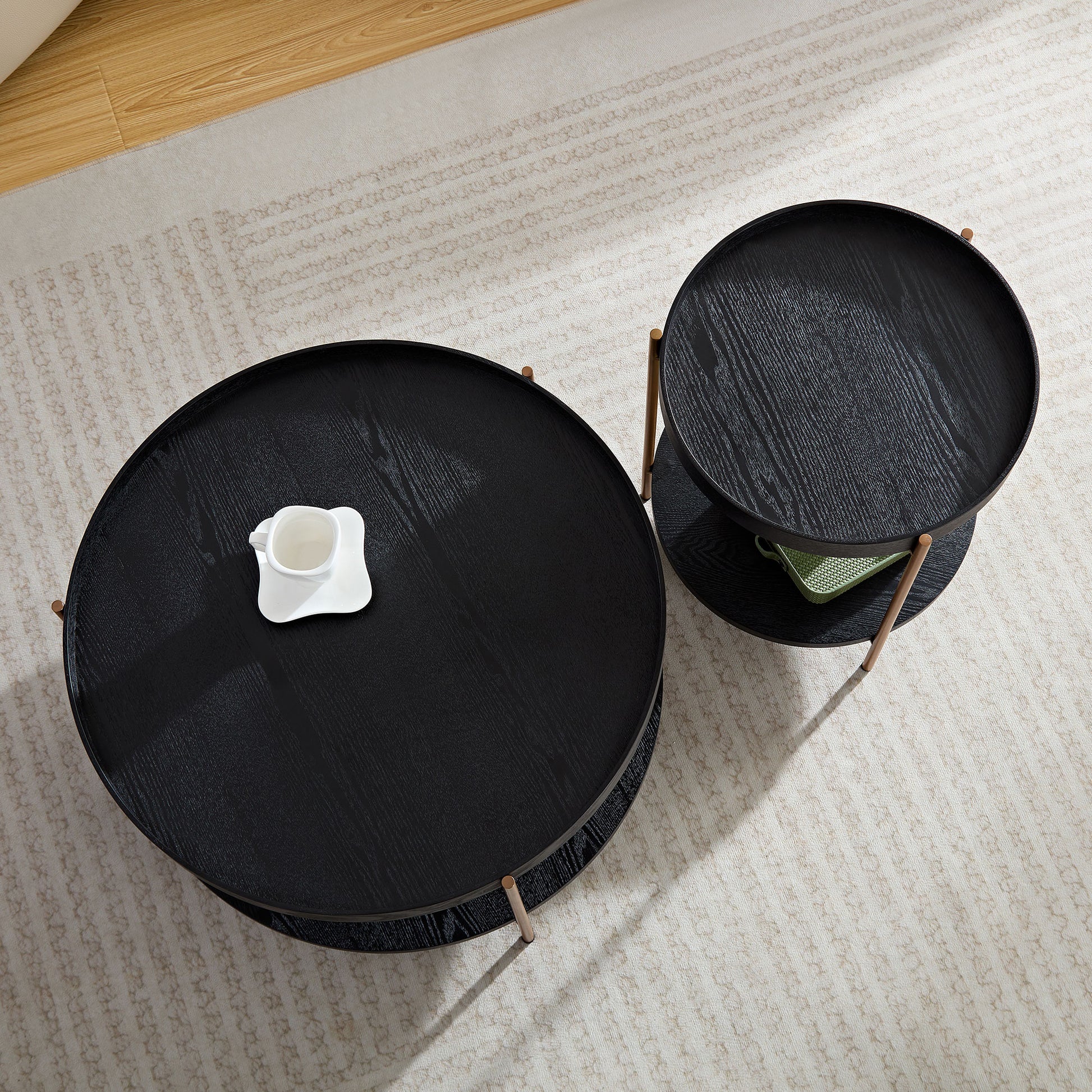 Black round nesting coffee tables with wood grain texture and modern design