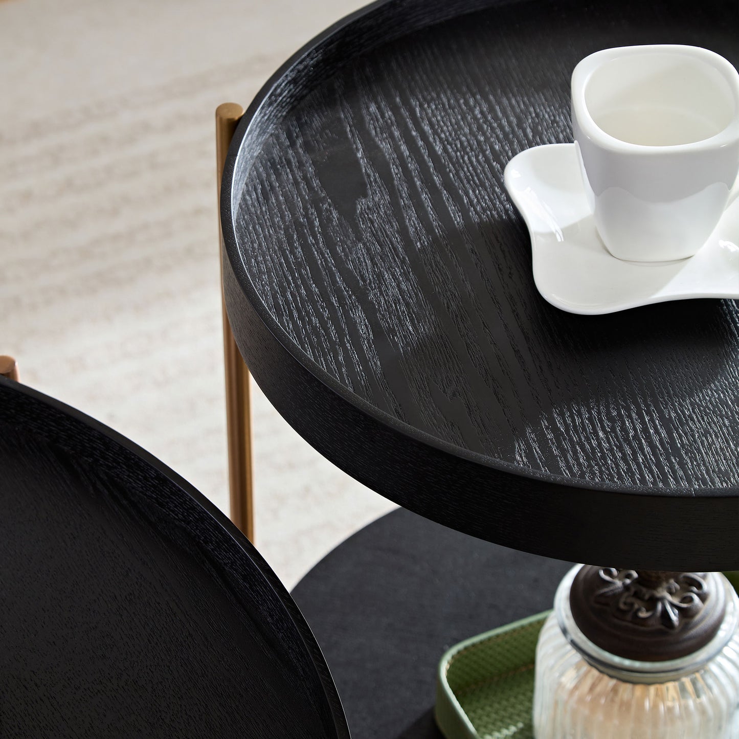Round black wood nesting table with gold accents and visible grain