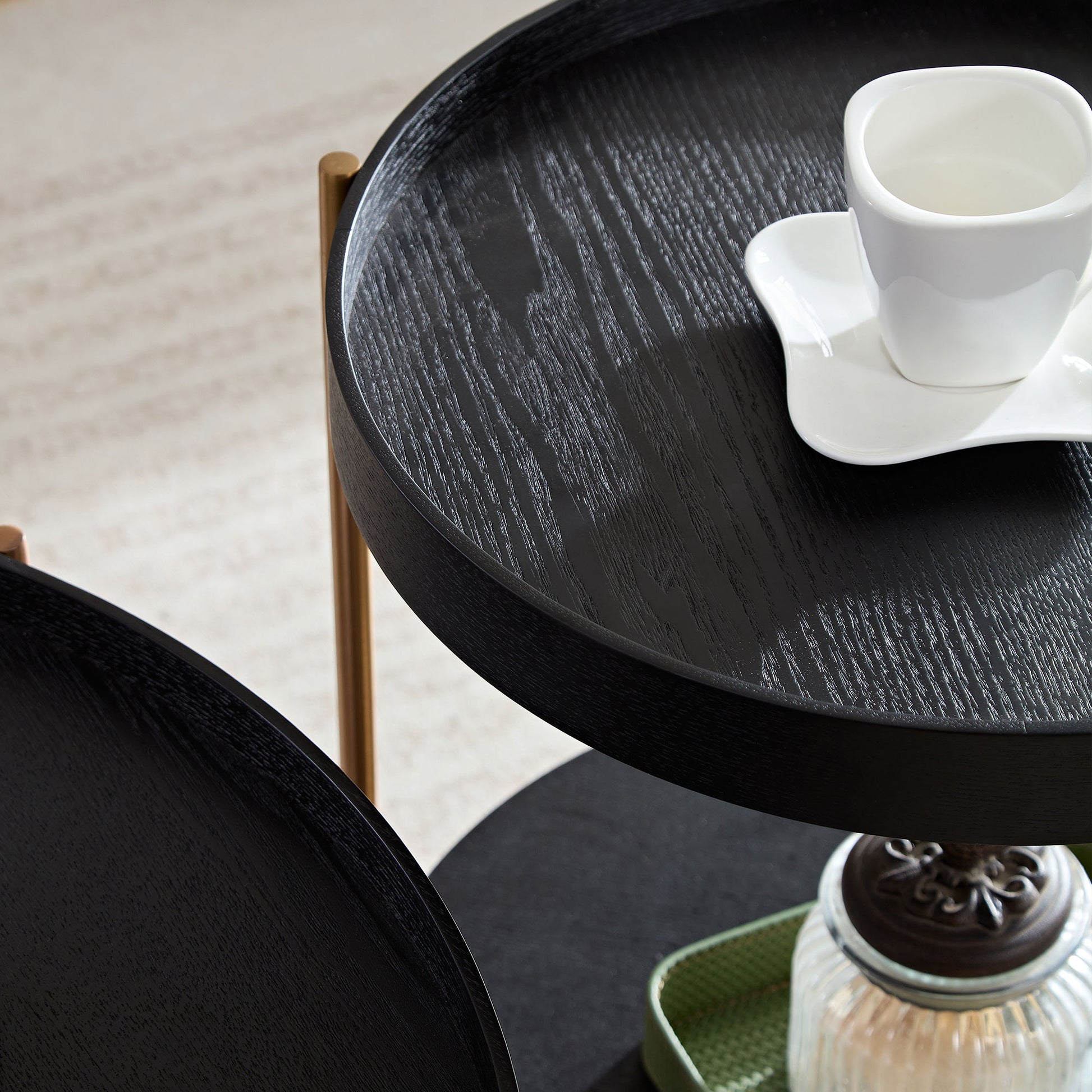 Round black wood nesting table with gold accents and visible grain