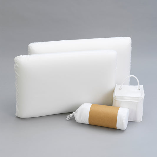 Two white rectangular pillows and a rolled pillow with brown band and bag