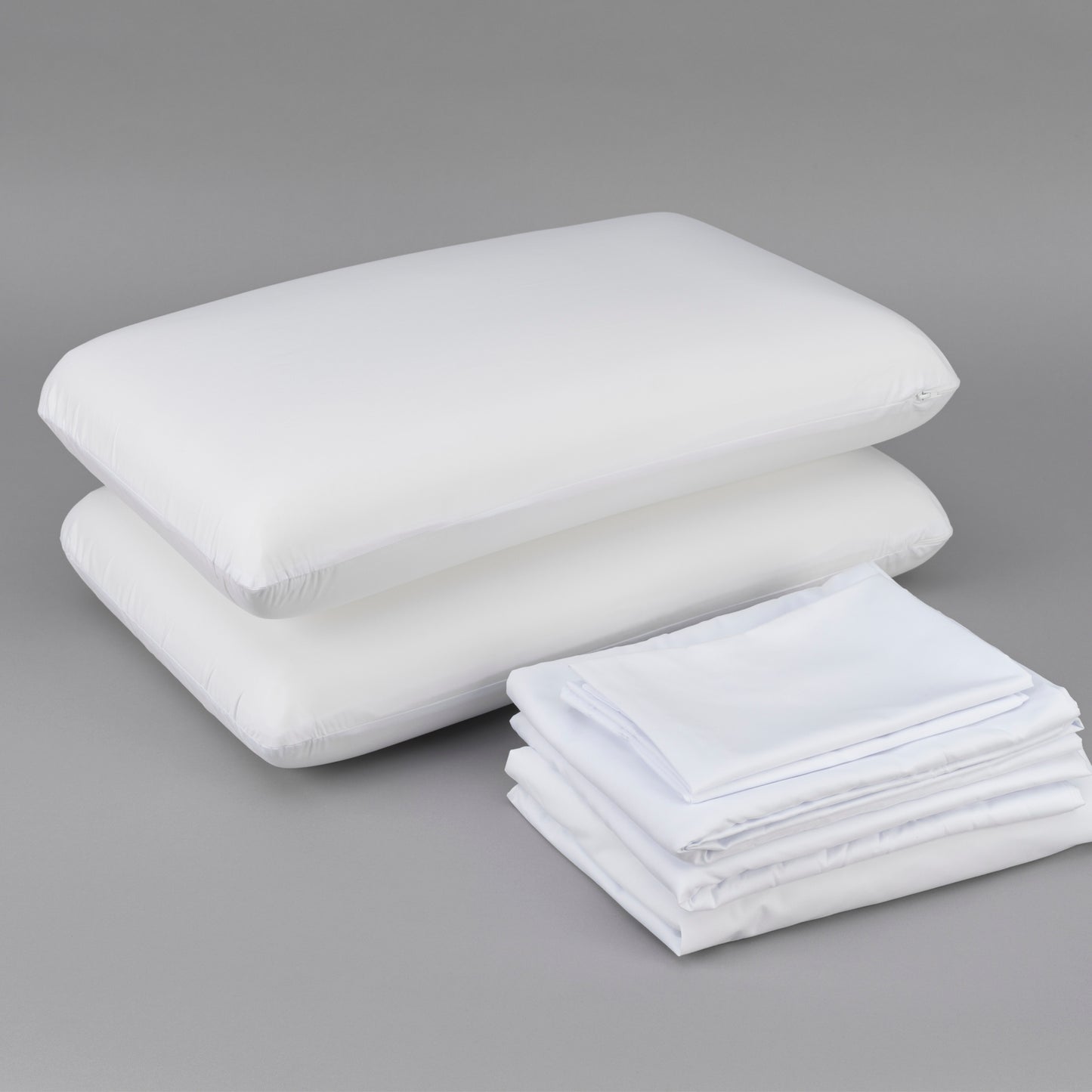 Stack of two white pillows and neatly folded white sheets perfect for bedding sets