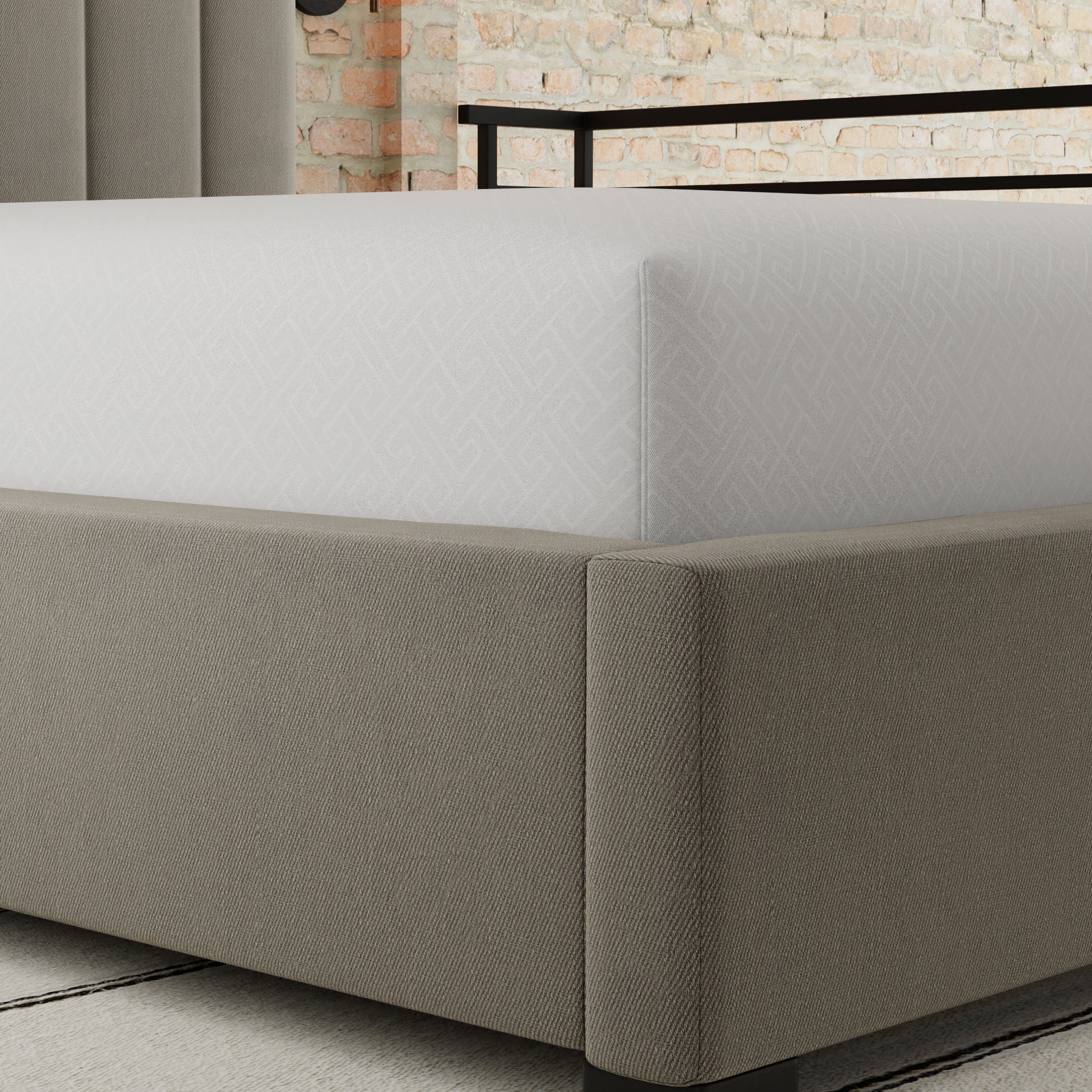 Upholstered beige bed frame with white geometric patterned fitted sheet