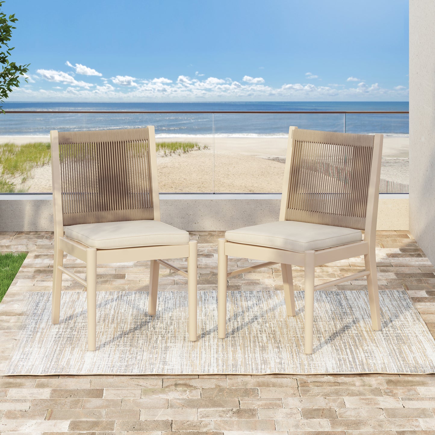 Pair of beige rope back dining chairs with cream cushions on a patterned outdoor rug