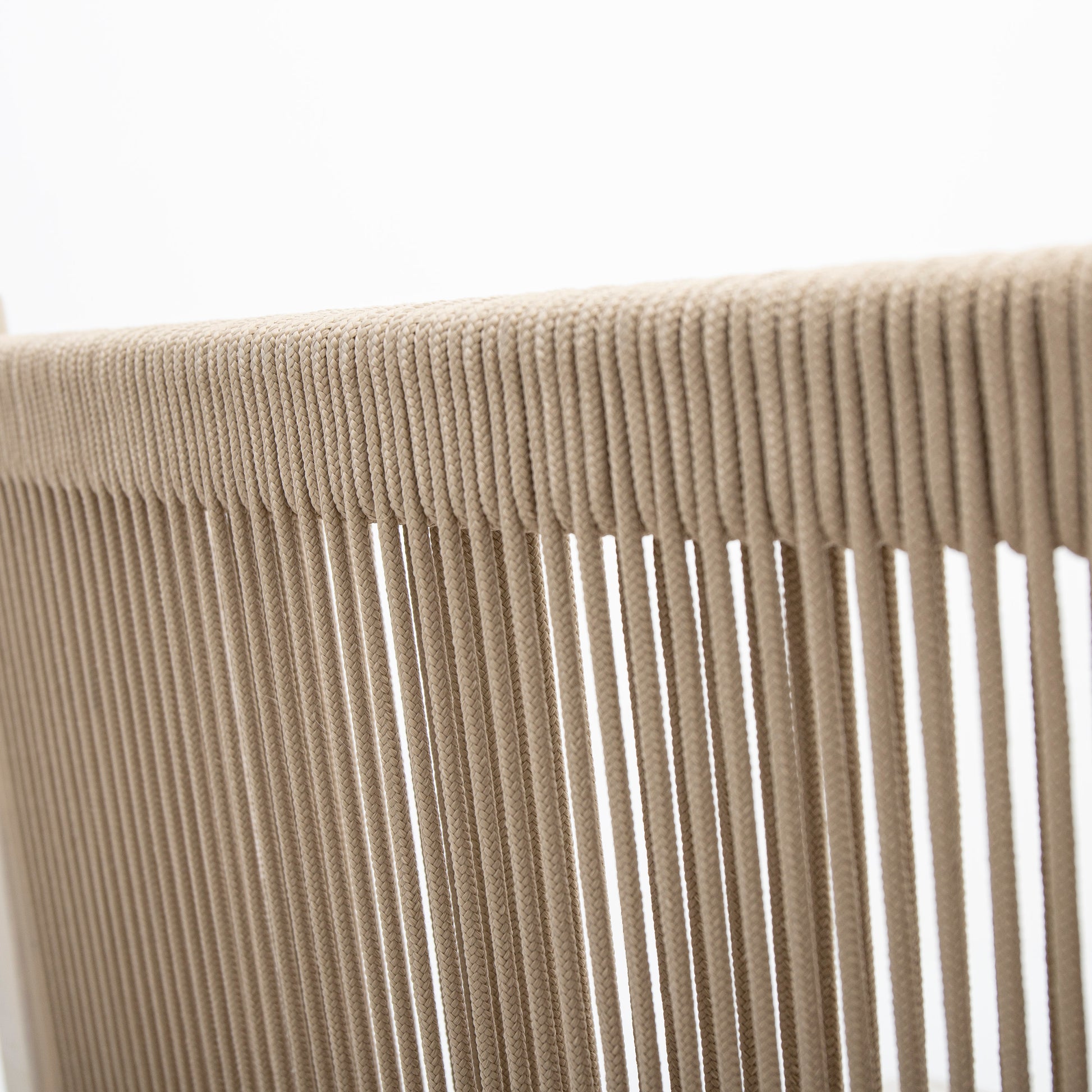 Closeup of a beige woven rope texture on an outdoor chair back