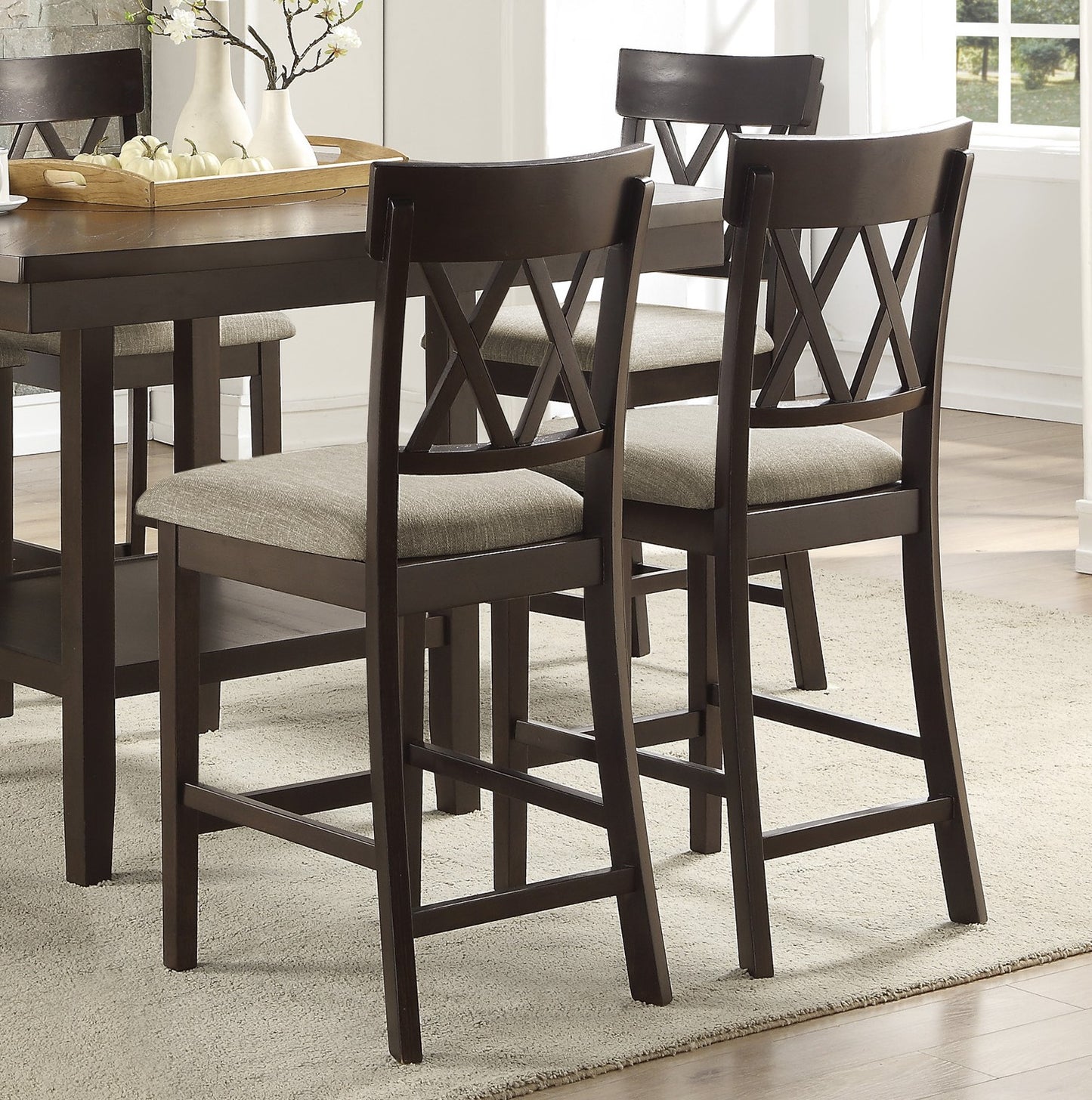 Dark wood counter height chairs with textured grey upholstered seats and crisscross back design