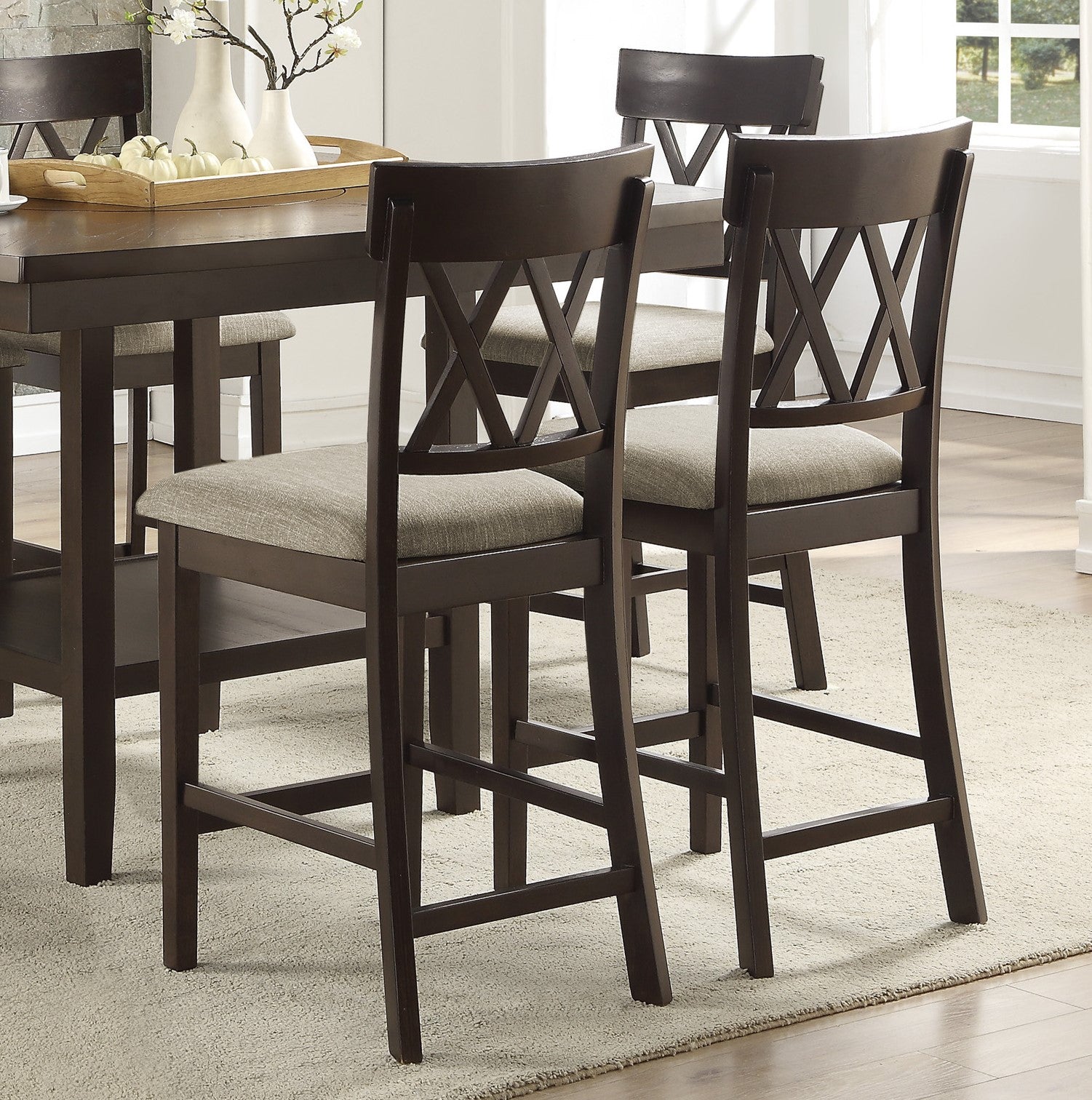 Dark wood counter height chairs with textured grey upholstered seats and crisscross back design