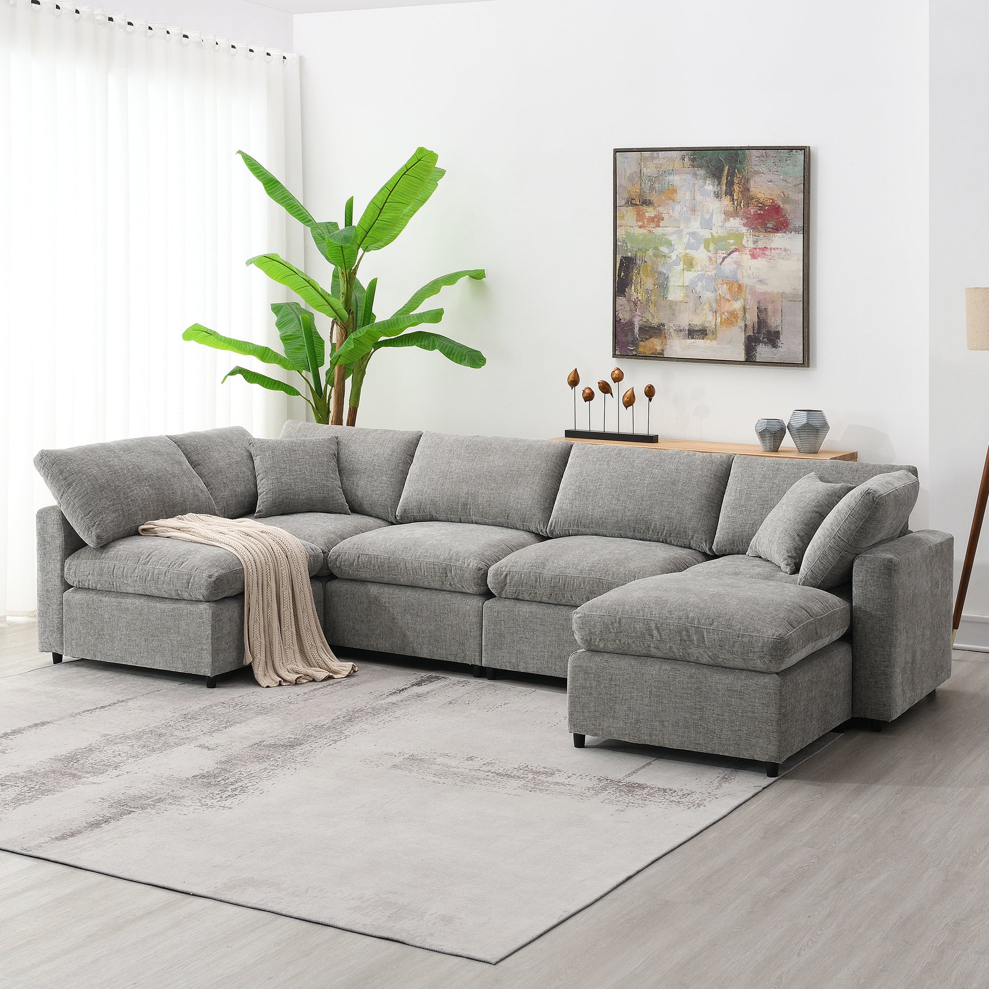 Gray sectional sofa with plush cushions and a cream throw blanket perfect for modern living rooms