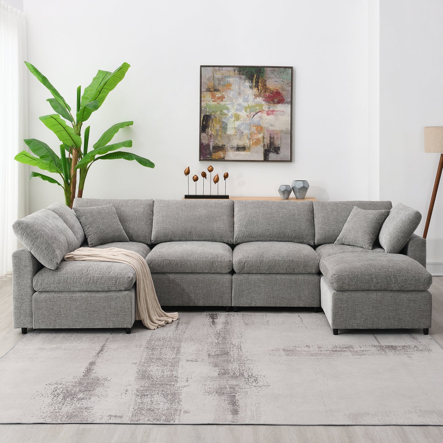 Spacious sectional sofa in light gray fabric with plush cushions and a rolled blanket