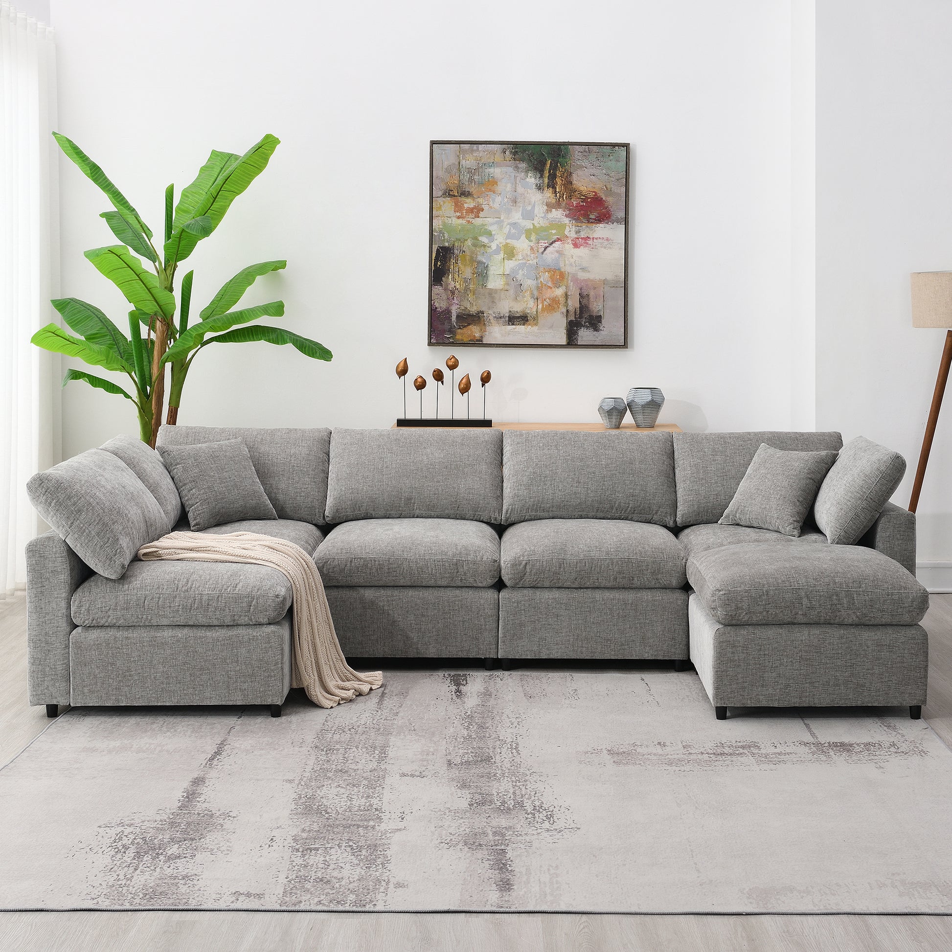 Spacious sectional sofa in light gray fabric with plush cushions and a rolled blanket