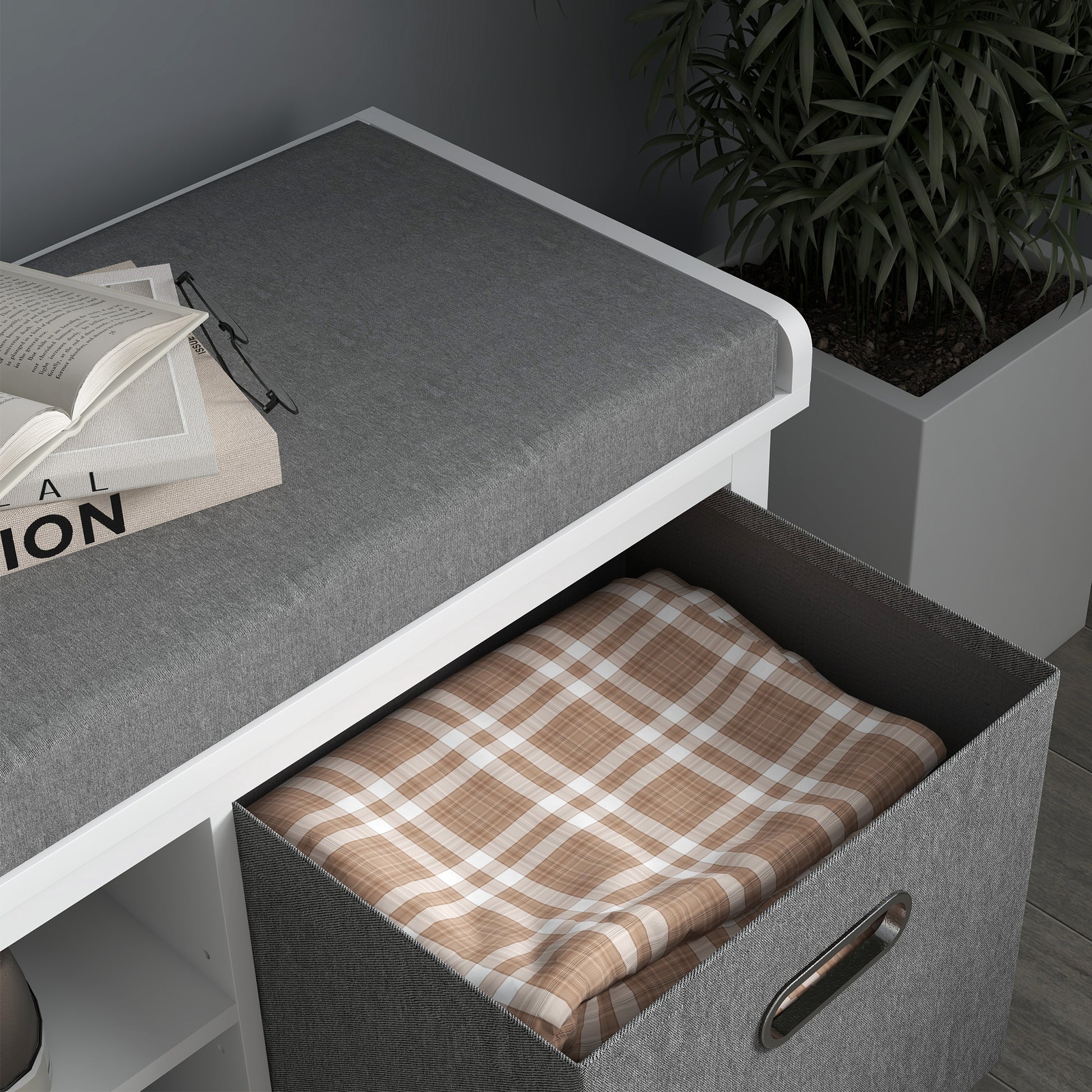 White storage bench with gray upholstered top and open drawer revealing a brown plaid blanket
