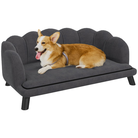 Pembroke Welsh Corgi rests on a plush grey dog sofa with scalloped edges
