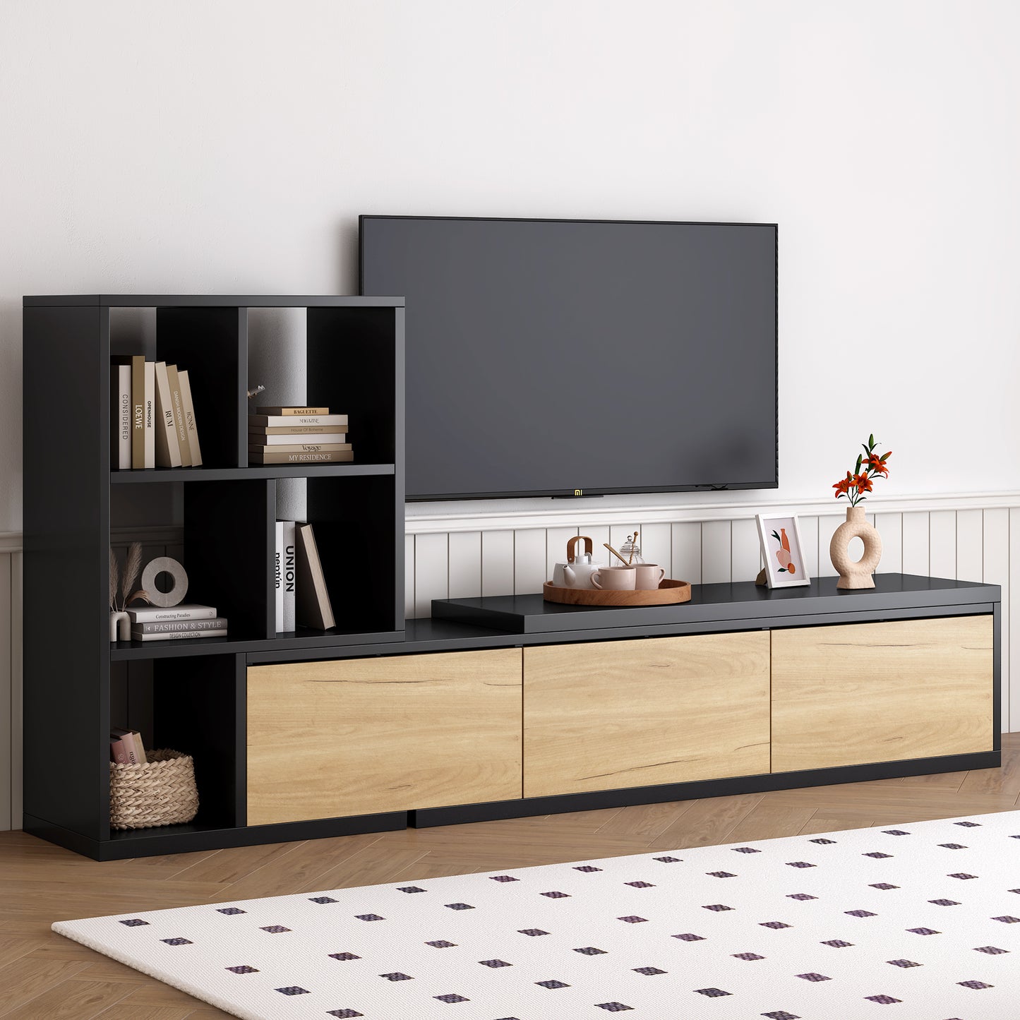 Black and wood media console with open shelves holding books and decor