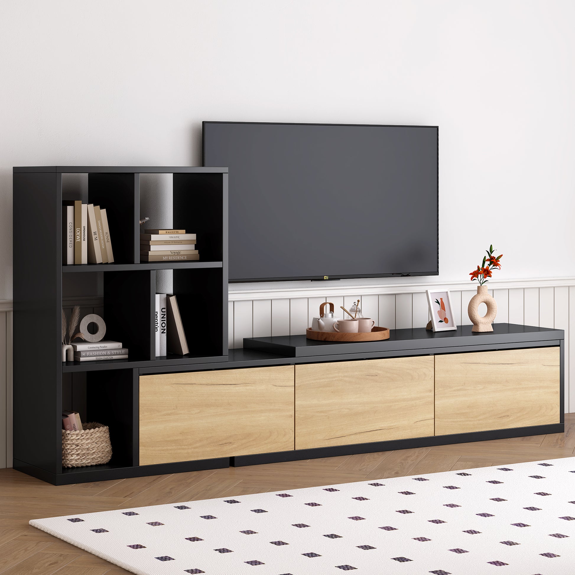 Black and wood media console with open shelves holding books and decor