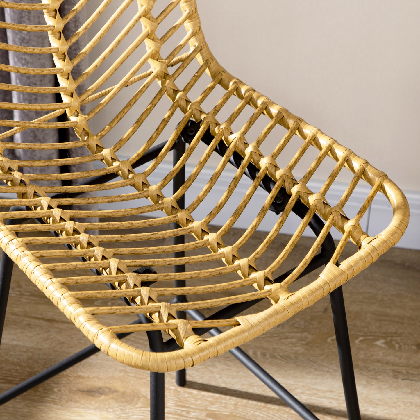 Natural rattan dining chair with black metal legs showcasing a woven seat and back