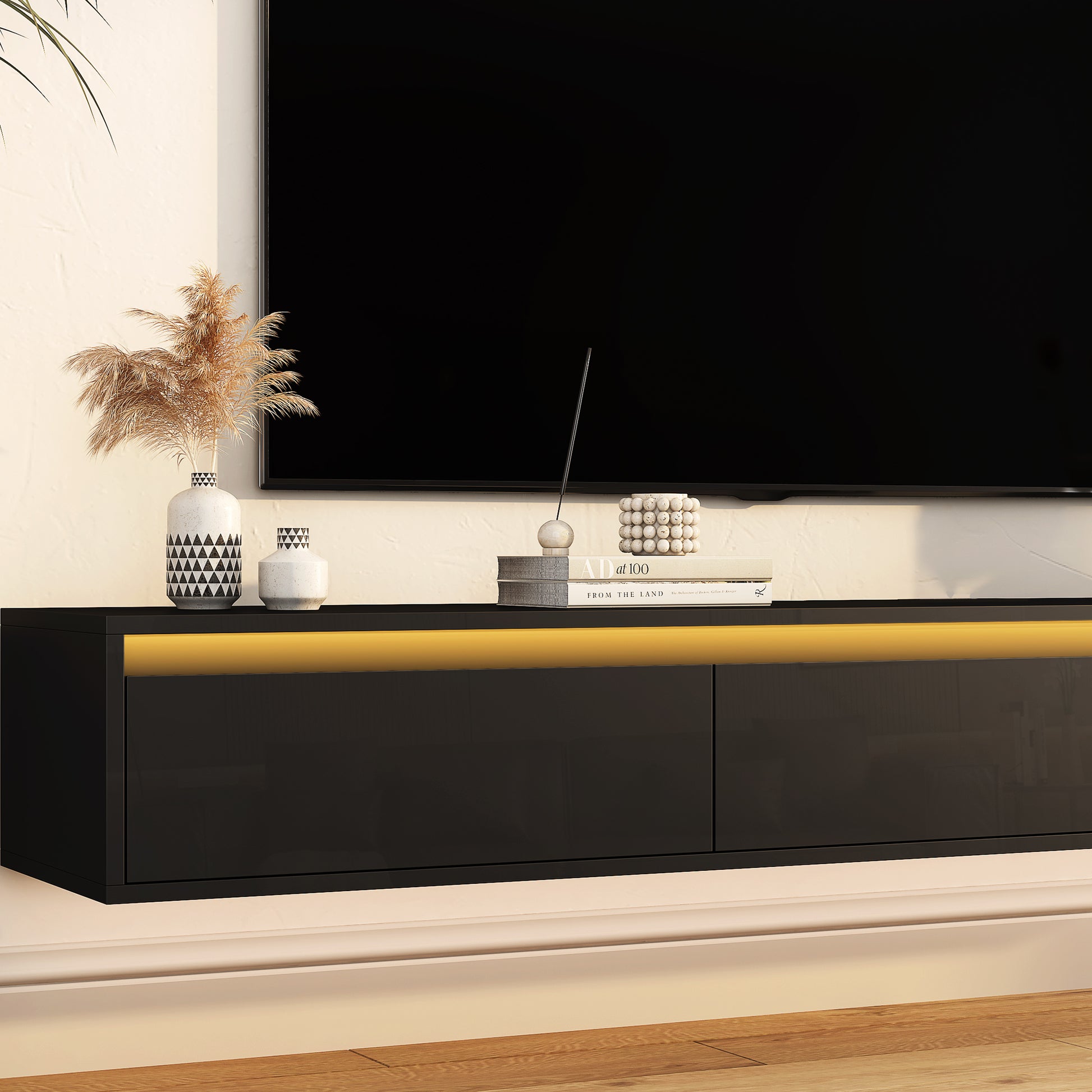 Sleek black wallmounted TV stand with integrated LED lighting and modern geometric vases