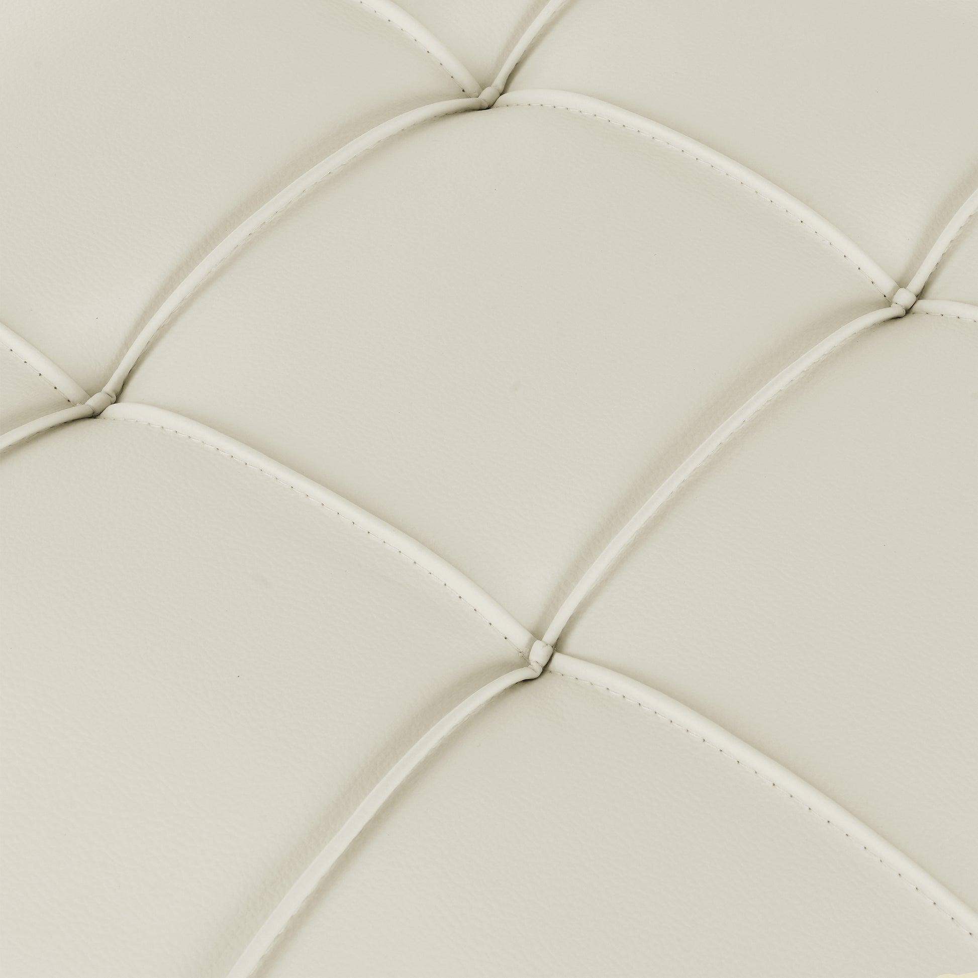 Closeup of ivory faux leather tufted upholstery fabric with diamond stitching detail