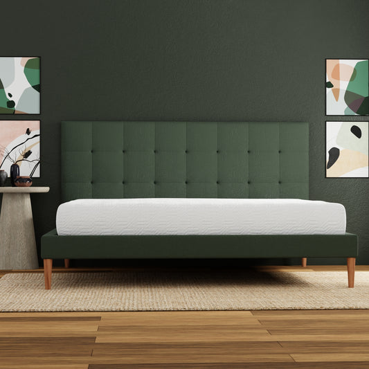 Deep green tufted headboard bed frame with white mattress on textured rug