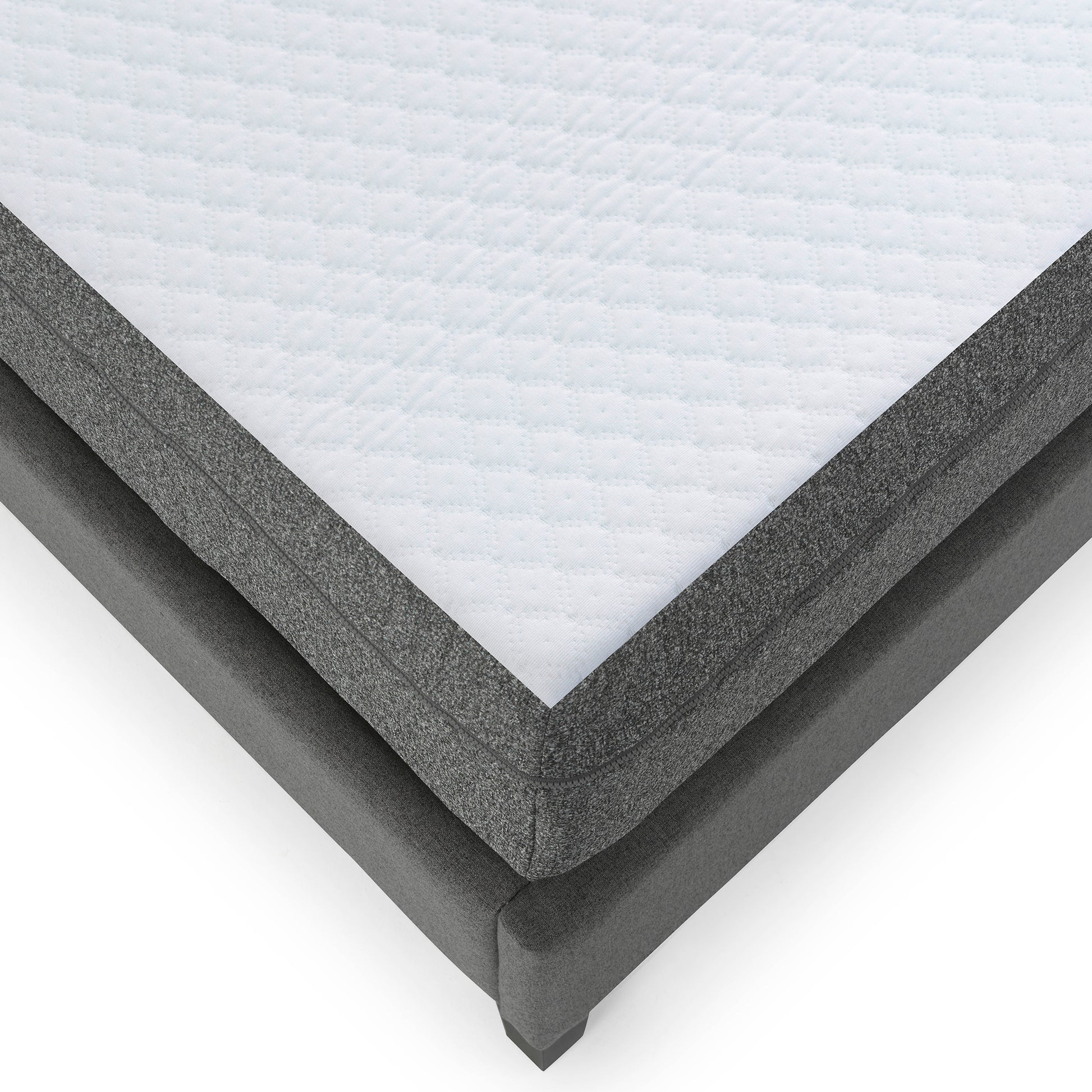 Close up of a quilted white mattress top with grey fabric border on a grey bed frame