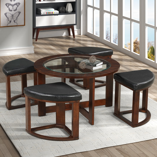 Round glass coffee table with four black upholstered ottomans on a patterned rug