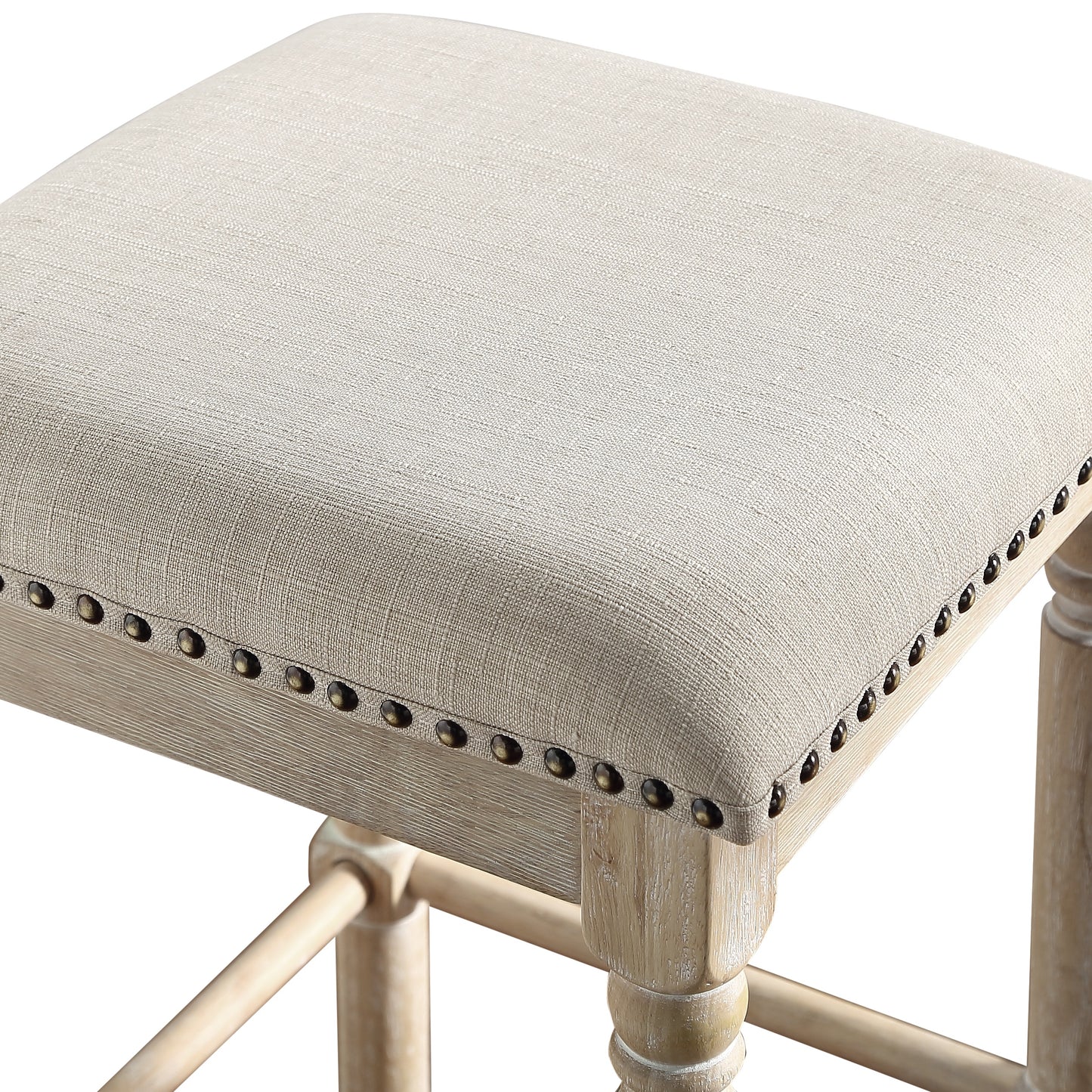 Cream fabric upholstered square stool with antique brass nailhead trim and distressed wood legs