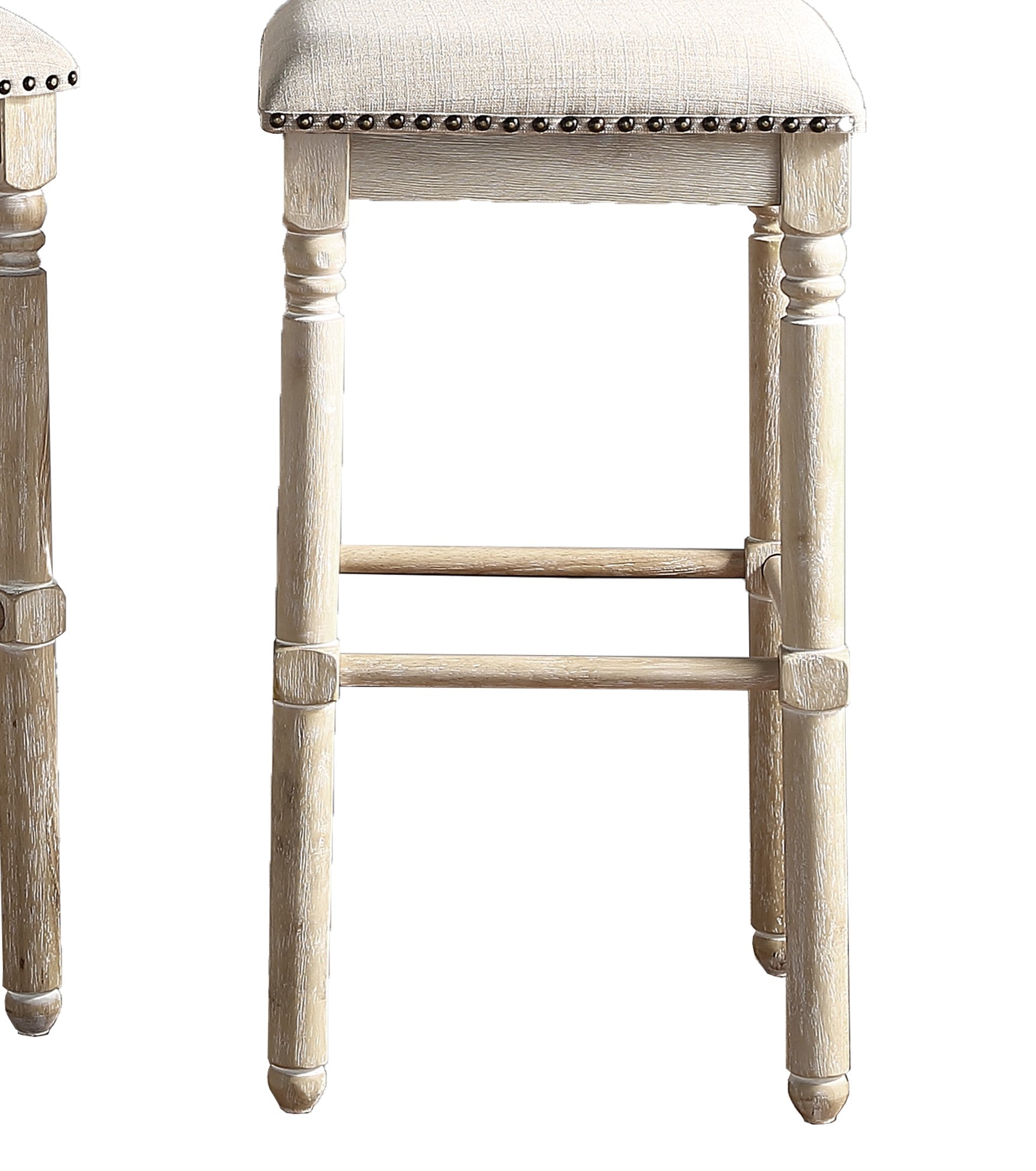 Distressed whitewashed wood bar stool with upholstered linen seat and brass nailhead trim