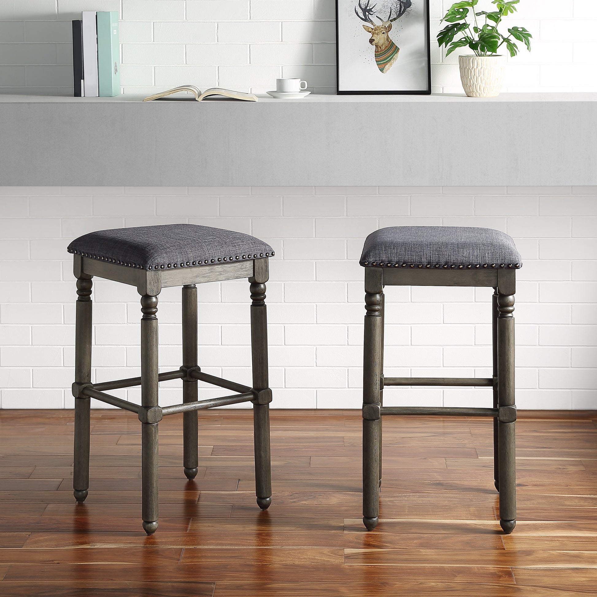 Gray upholstered bar stool with nailhead trim and dark wood legs perfect for kitchen islands