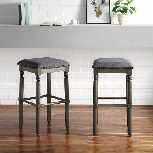 Gray upholstered bar stool with nailhead trim and dark wood legs perfect for kitchen islands
