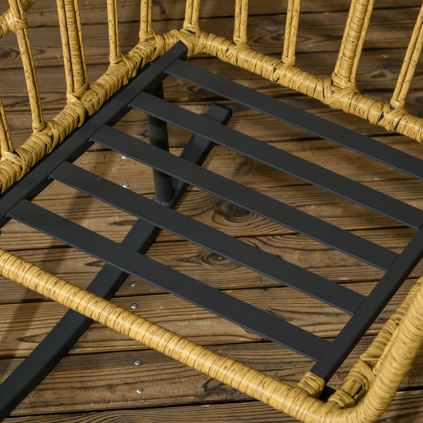Closeup of a yellow wicker chair seat with a black metal frame