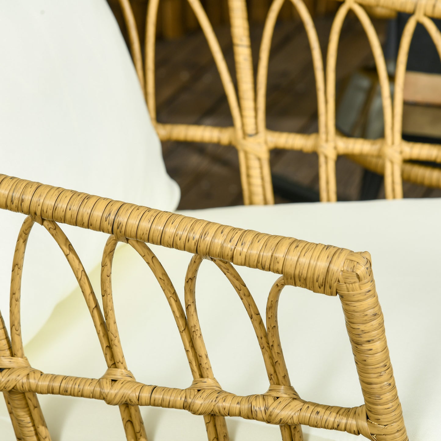 Closeup of a natural wicker chair armrest with white cushion outdoor furniture detail