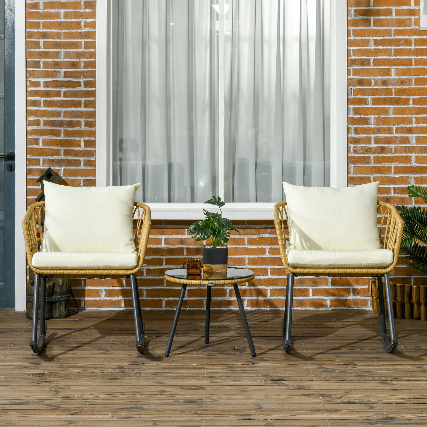 Wicker rocking chair with cream cushion and metal base for outdoor seating