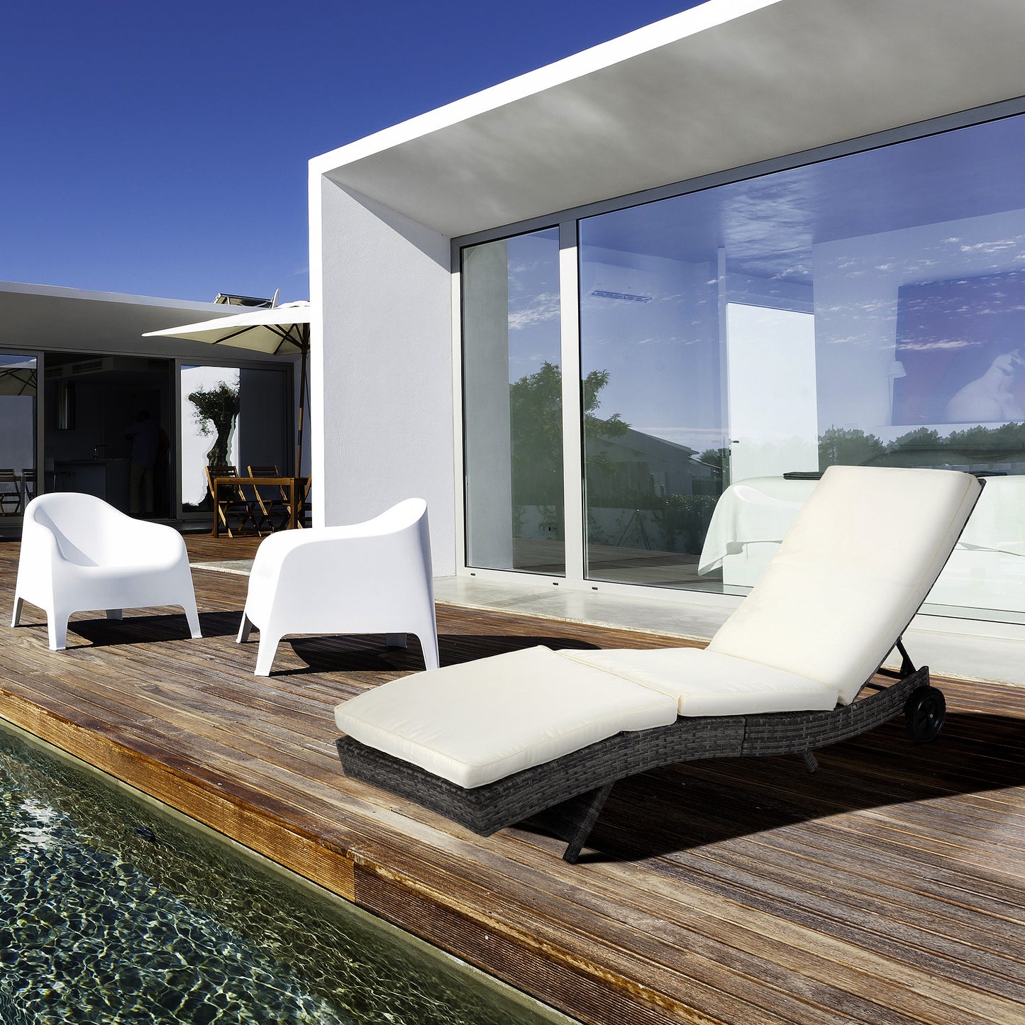 Dark grey wicker chaise lounge with cream cushions poolside lounger