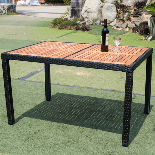 Rectangular outdoor dining table with acacia wood top and black rattan base perfect for patio use