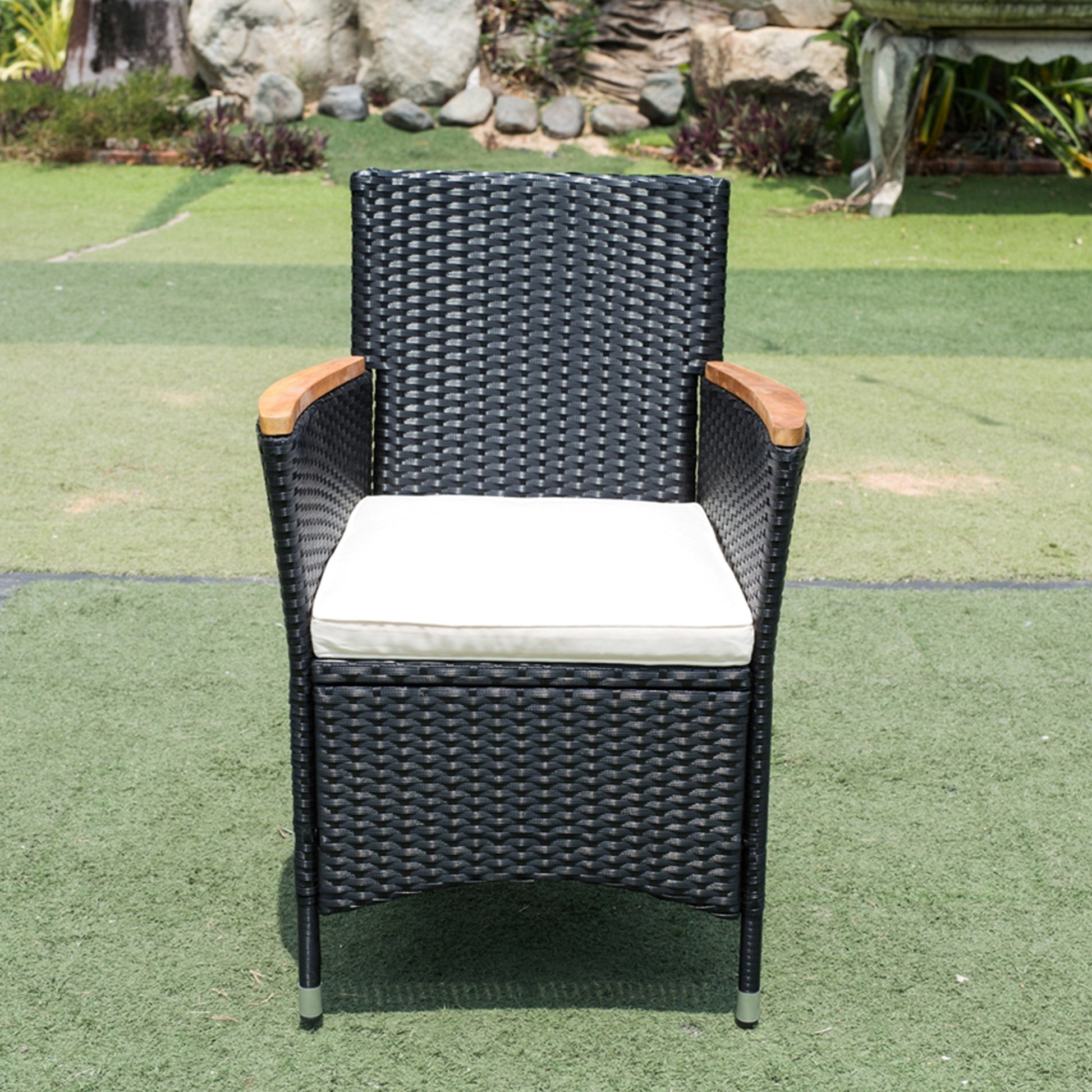 Black rattan outdoor chair with cream cushion and wooden arms
