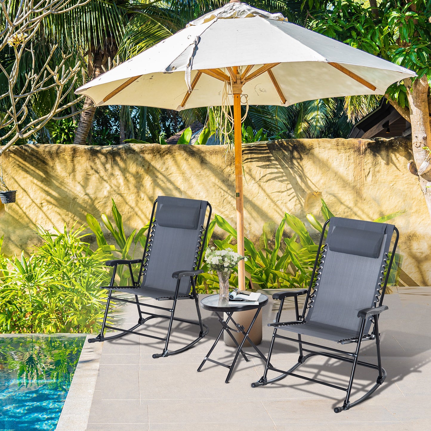 Two dark gray zero gravity chairs with adjustable headrests beside a pool