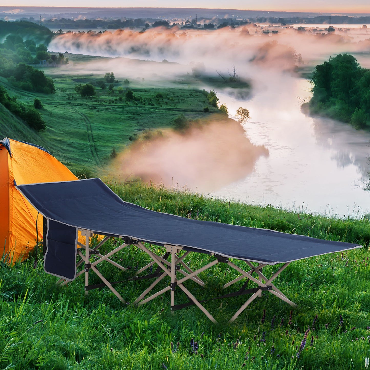 Dark blue folding camping cot with metal frame set up on green grass next to an orange tent