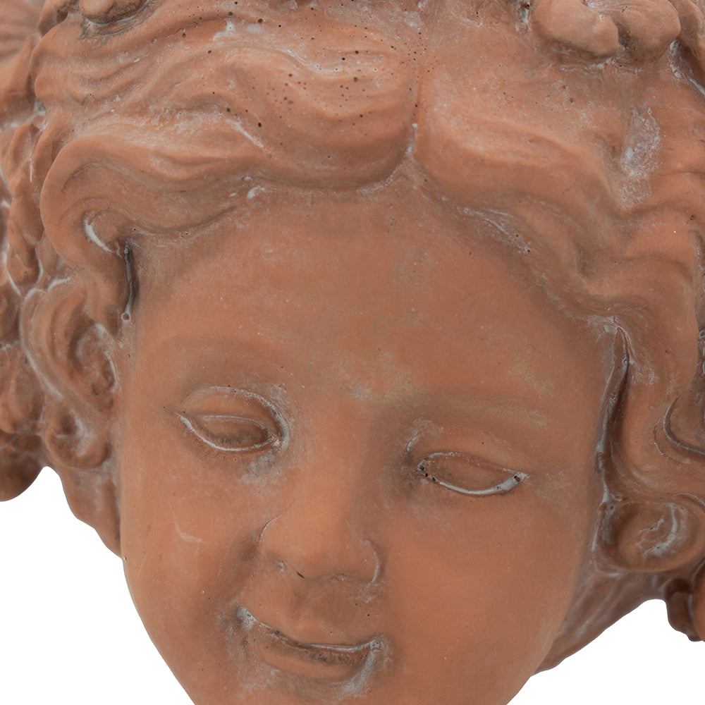 Terracotta cherub planter detail with curly hair and closed eyes