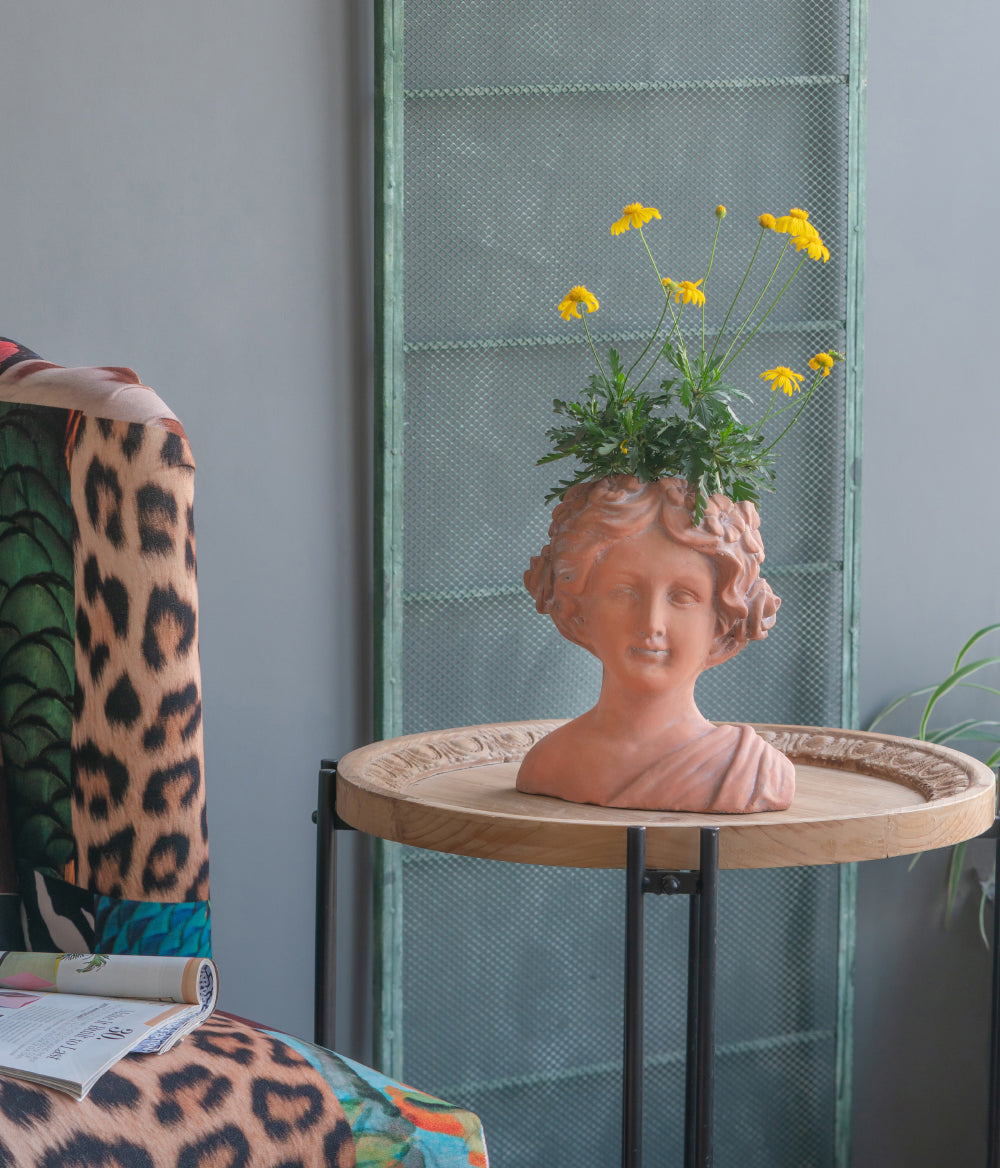 Terracotta bust planter with yellow daisies adds artistic flair to home decor