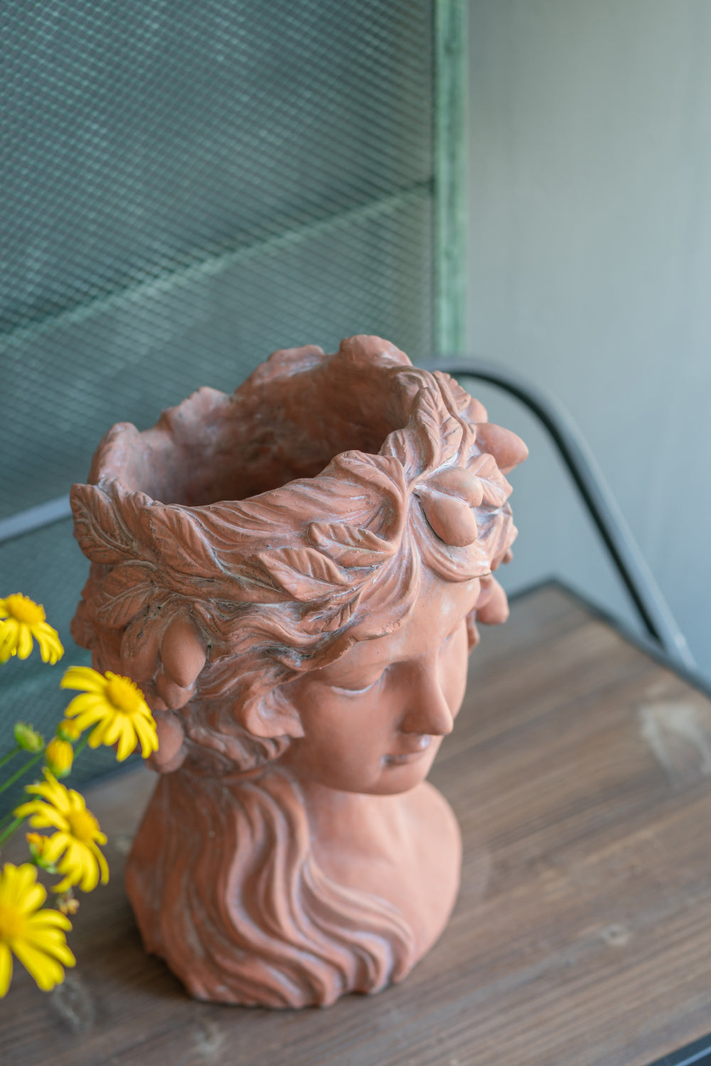 Terracotta bust planter with ornate laurel wreath detail perfect for indoor plants