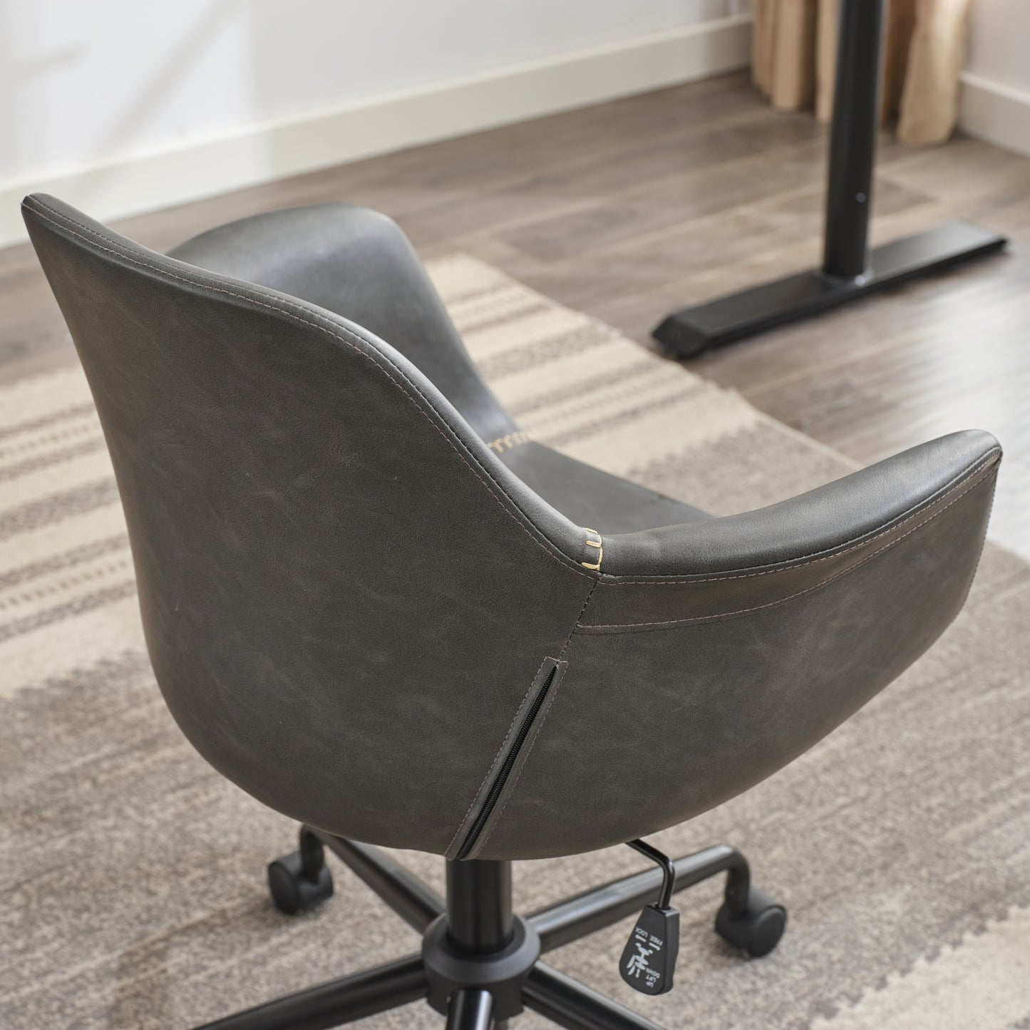 Dark grey faux leather ergonomic office chair with accent stitching and lumbar support