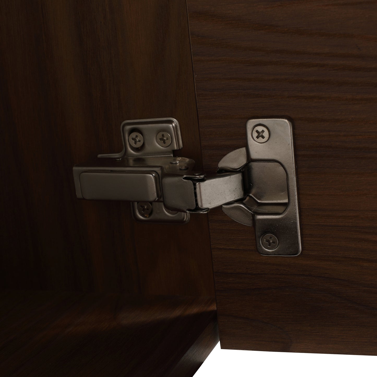 Closeup of brushed nickel cabinet hinge attached to dark walnut wood door