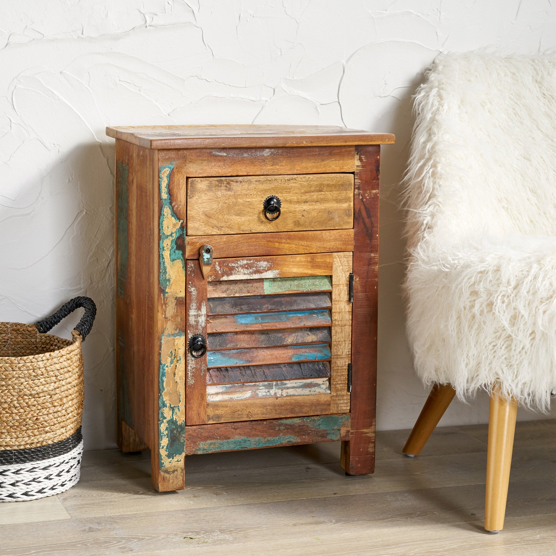 Distressed wooden bedside table with one drawer and louvered door featuring multicolored reclaimed wood