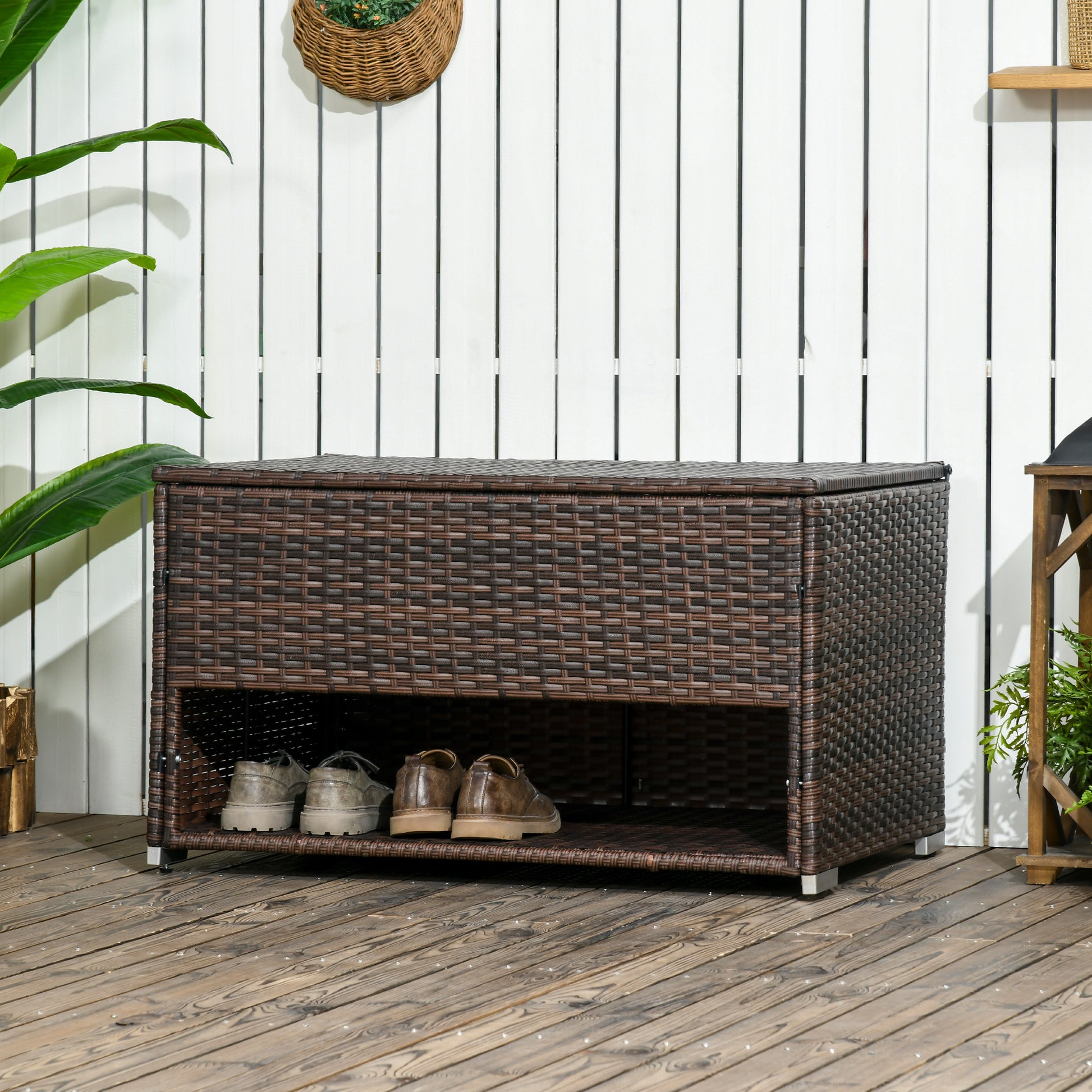 Brown rattan shoe bench with two shelves holding mens dress shoes for entryway organization