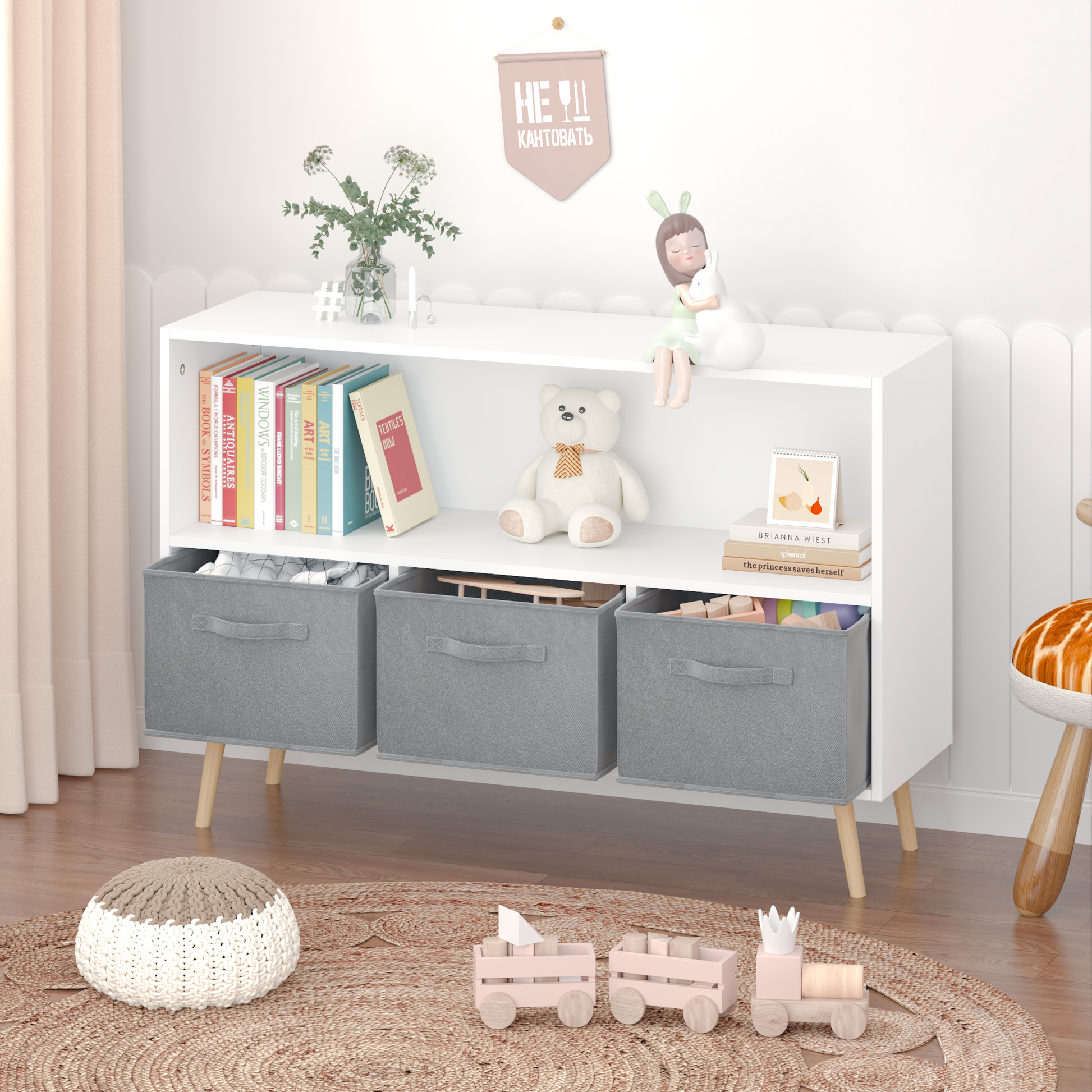 White modern toy storage shelf with three grey fabric bins and various childrens books and toys