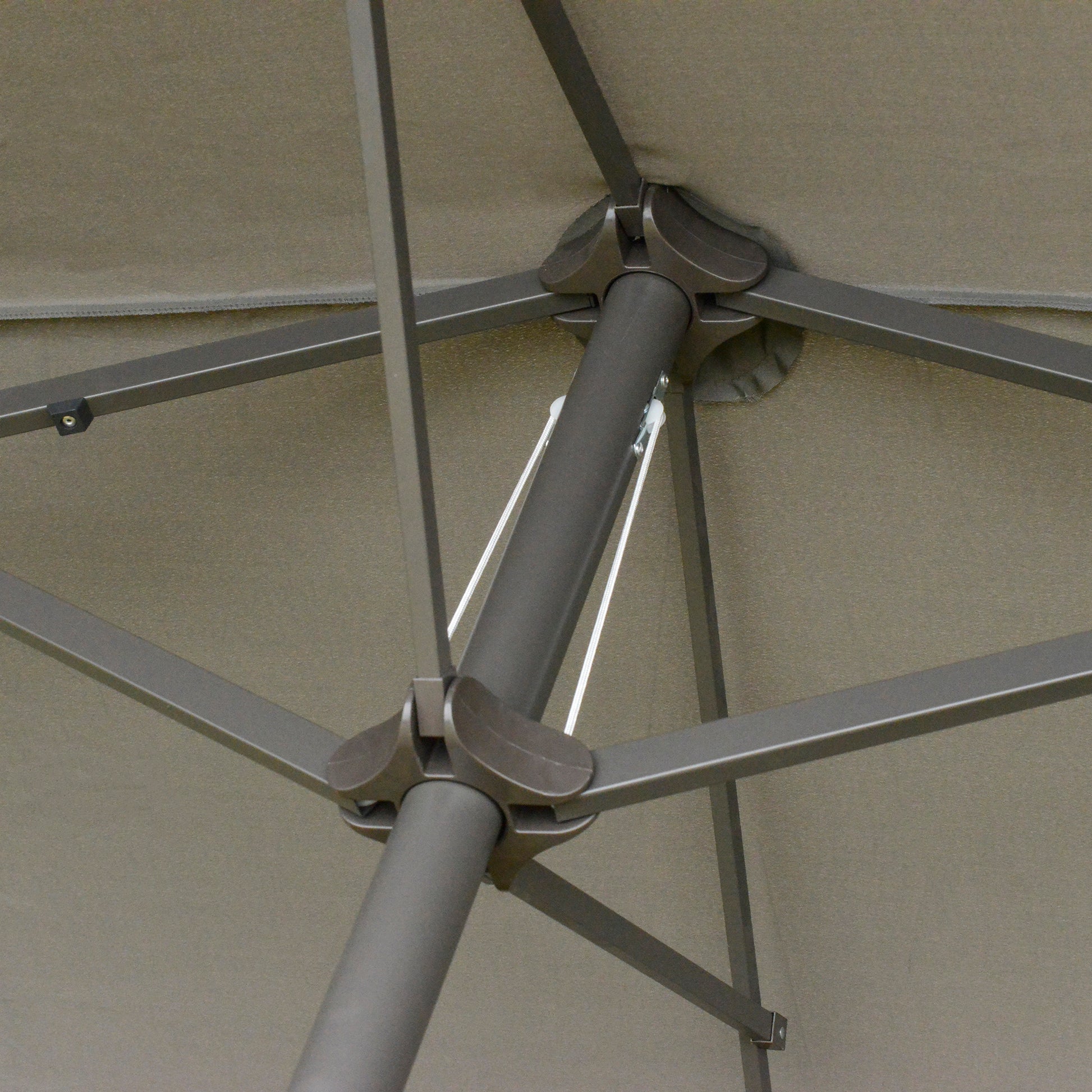 Closeup of tan umbrella fabric with metal pole and rib structure