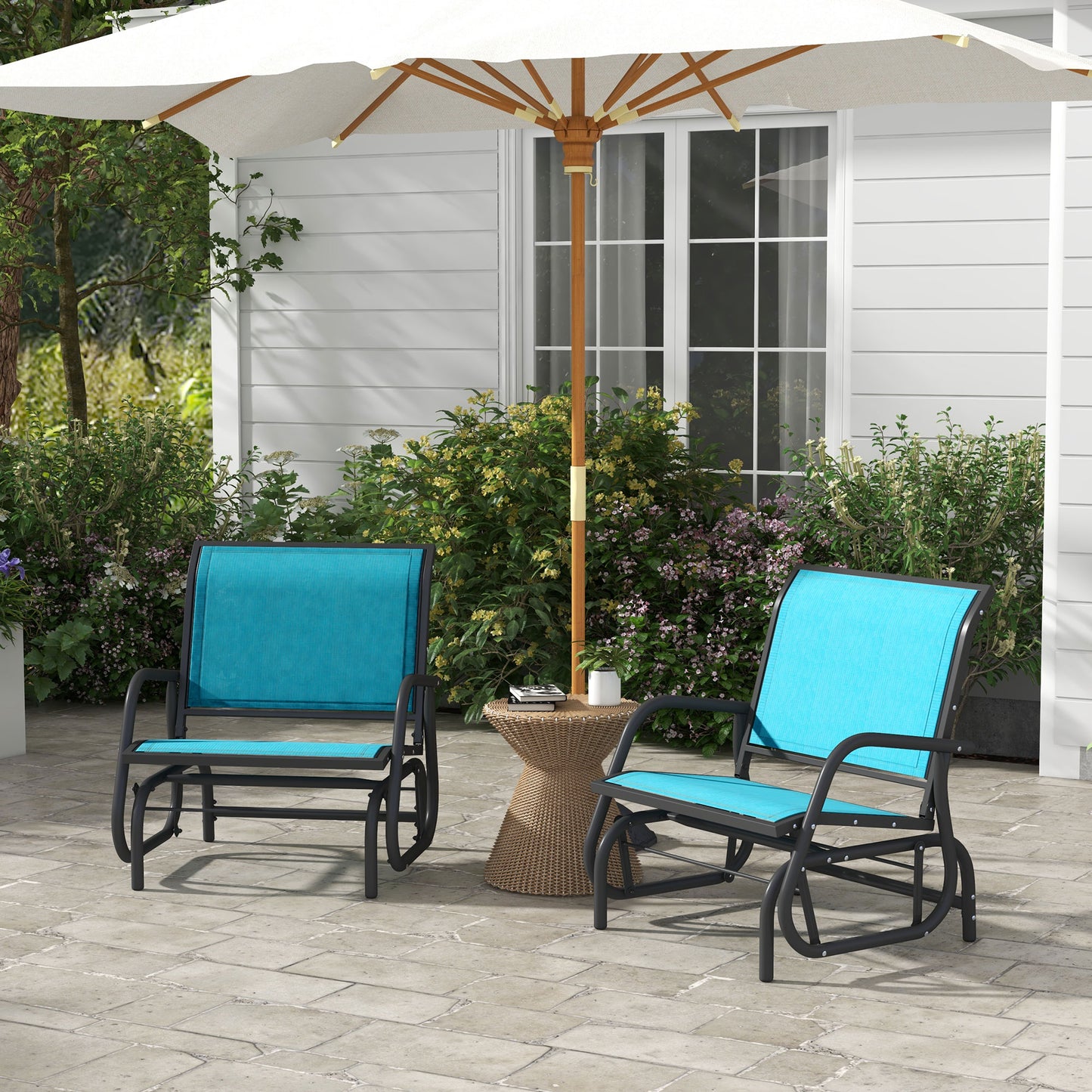 Two blue metal outdoor glider chairs with black frames and cushions sit on a patio
