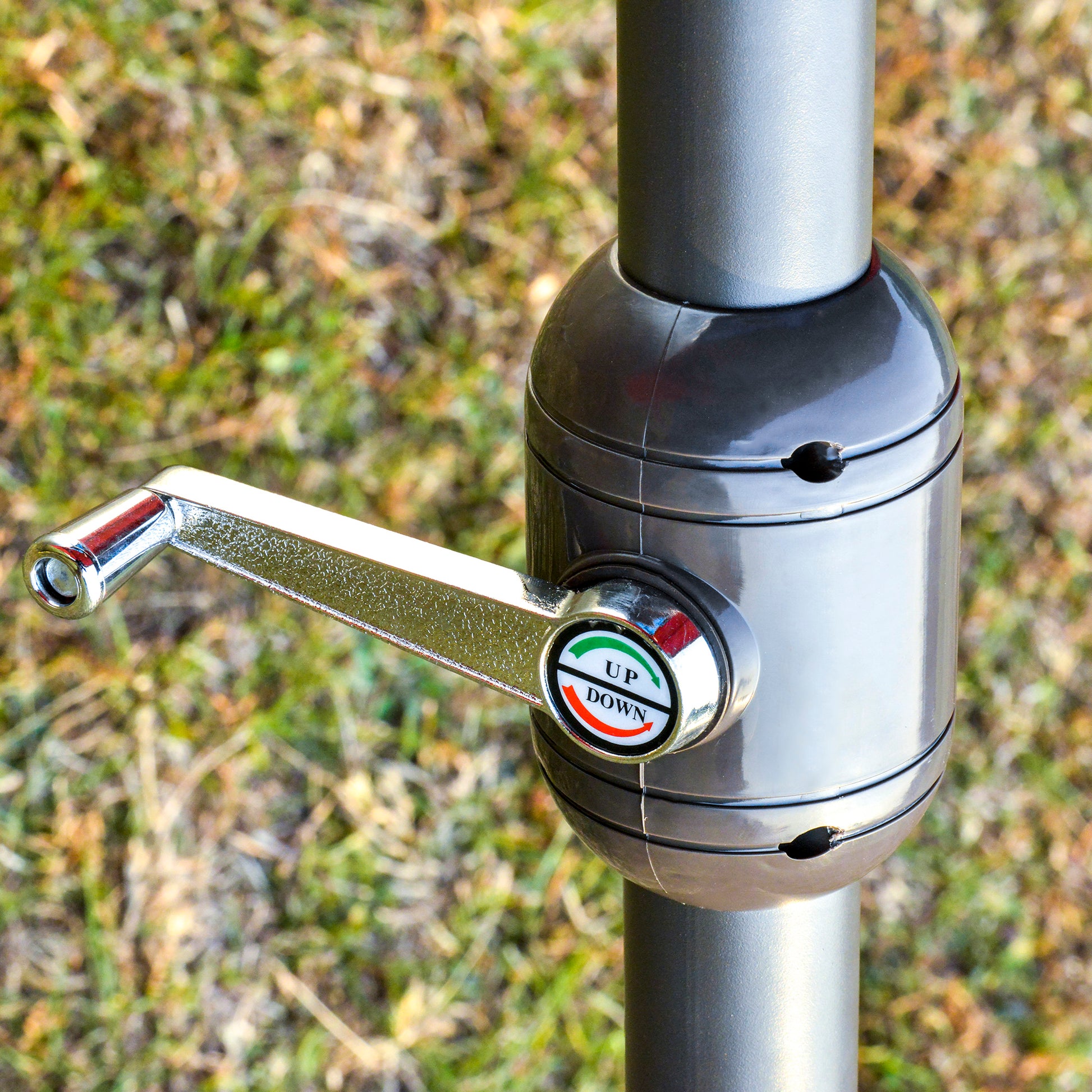 Closeup of grey patio umbrella crank with UP DOWN indicator