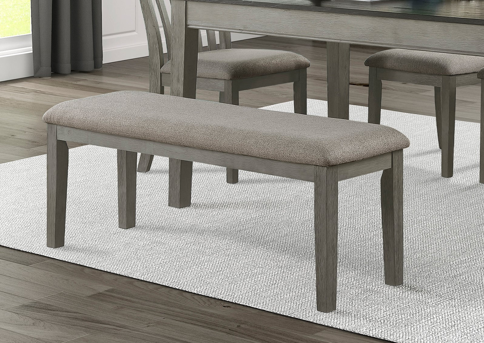 Gray upholstered dining bench with weathered oak finish legs